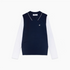A navy blue knit sweater vest layered over a white long-sleeve collared shirt, featuring a small white embroidered rooster logo on the left chest. 