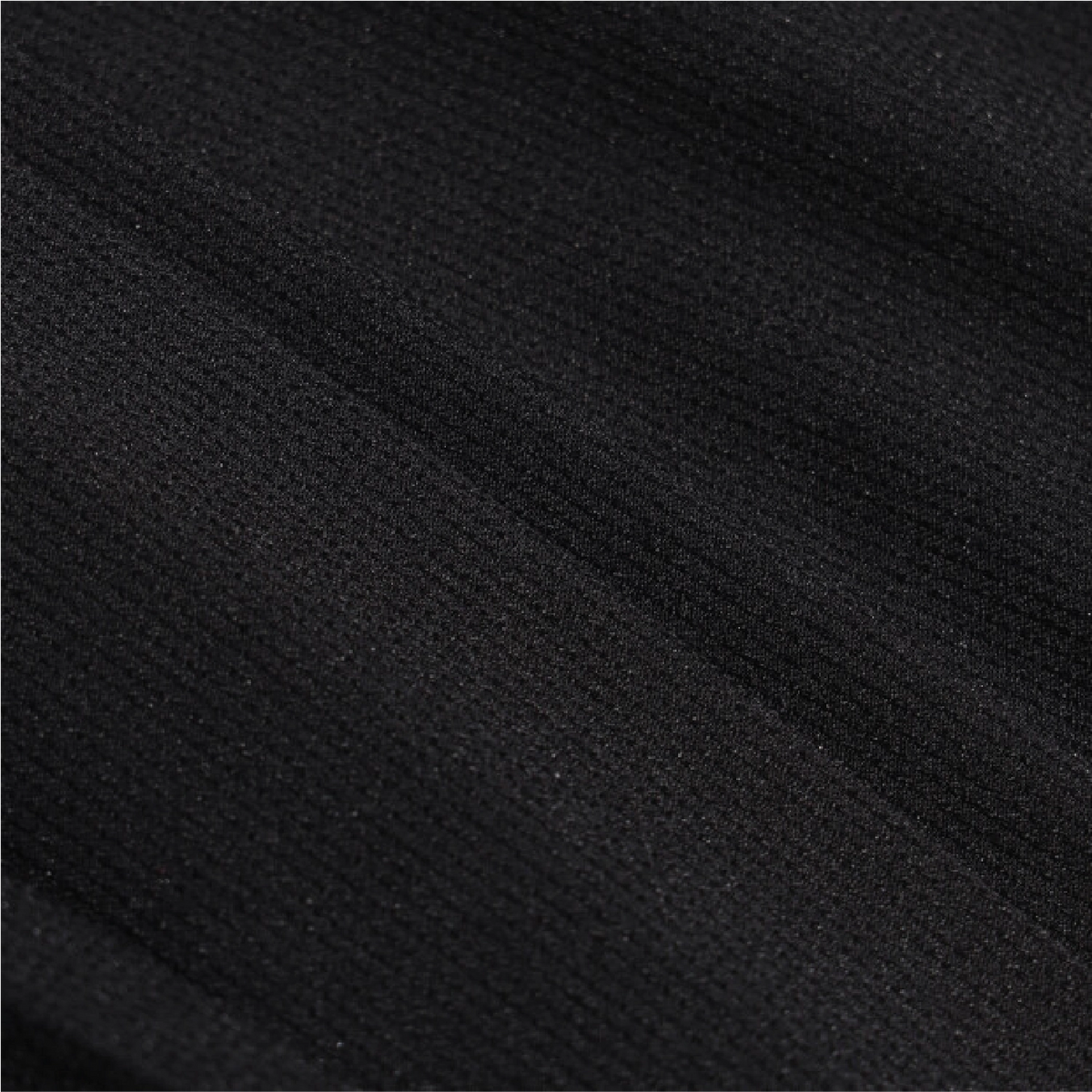 A close-up of black textured fabric with a fine ribbed or woven surface and soft diagonal folds.