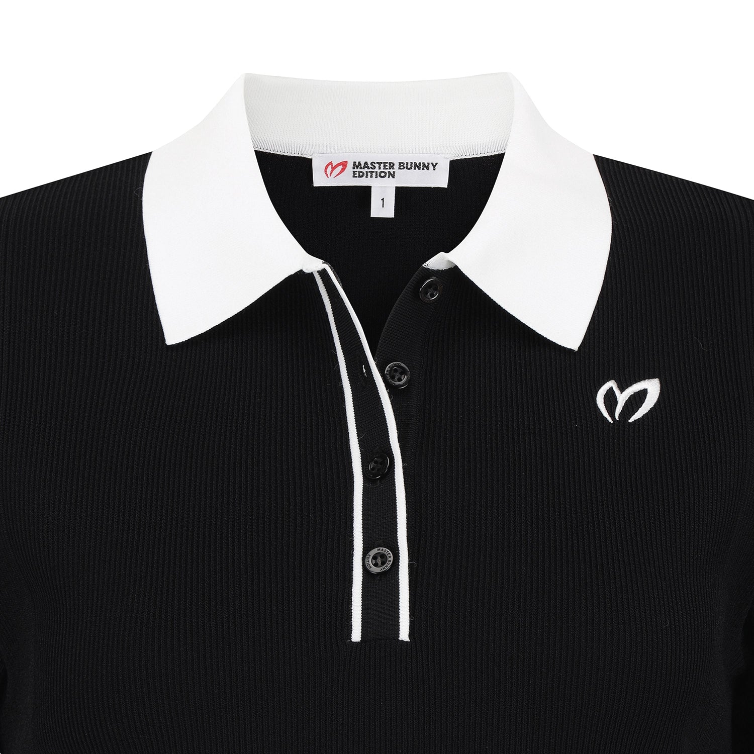 A close-up of a black ribbed knit polo shirt with a contrasting white collar, white piping along the placket, and a white embroidered logo on the chest. The inner neck label reads 'MASTER BUNNY EDITION'.