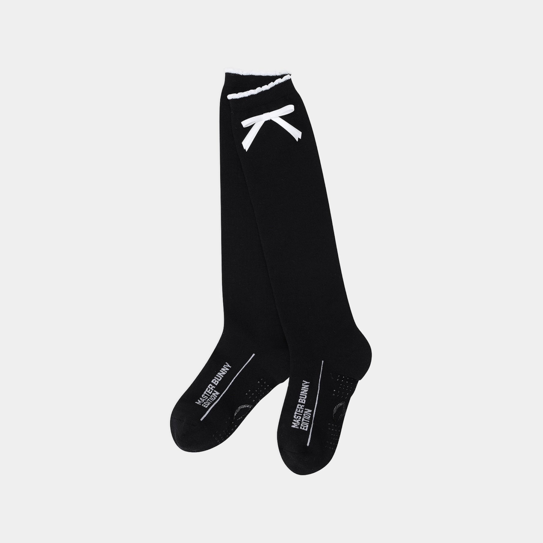 A pair of black athletic knee-high socks with white graphic details, including a stylized ribbon near the top cuff and white text on the toes, displayed against a light gray background.