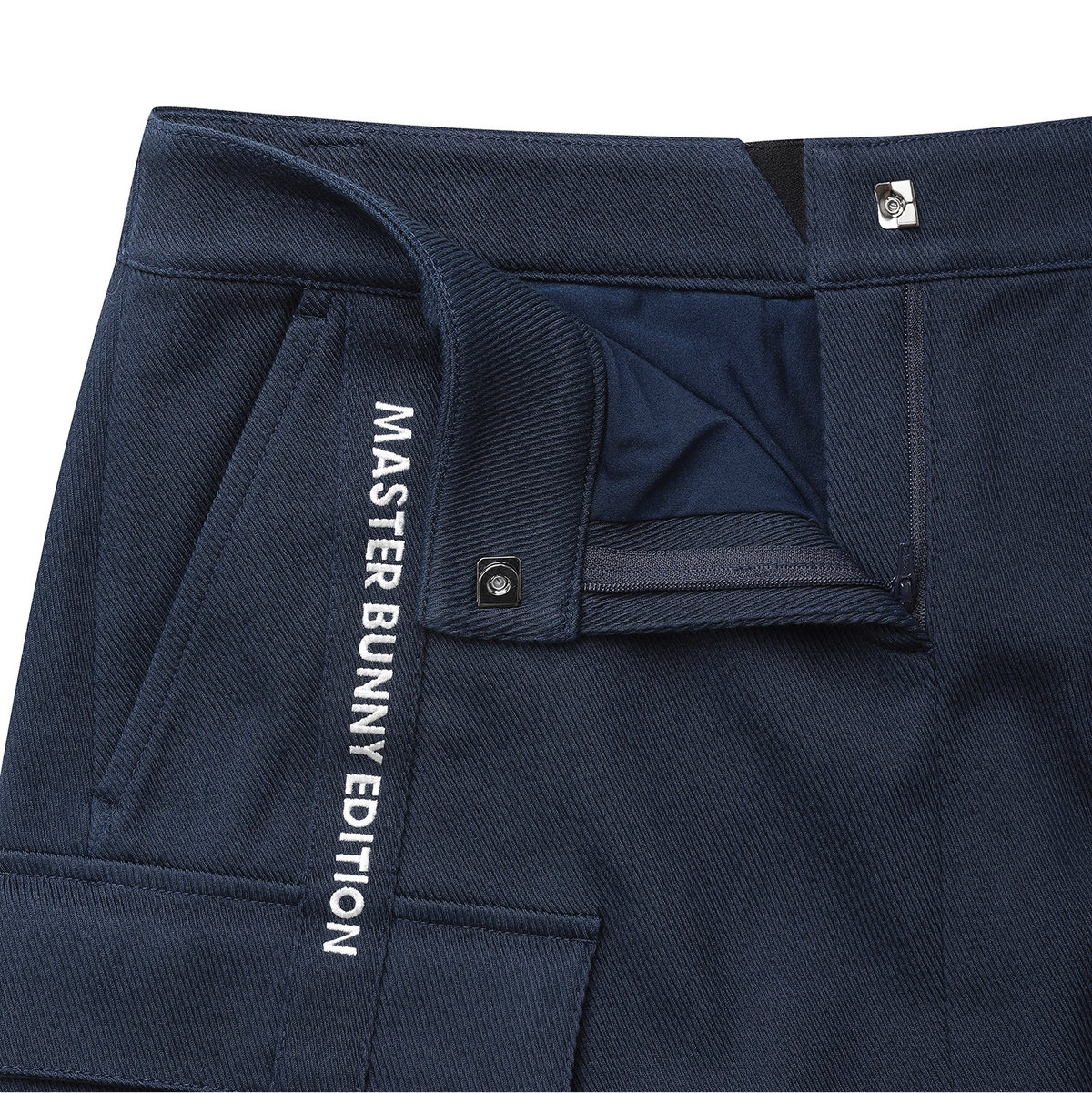 Close-up of navy blue pants showing the waistband, pocket, and white vertical text reading 'MASTER BUNNY EDITION' on the side.