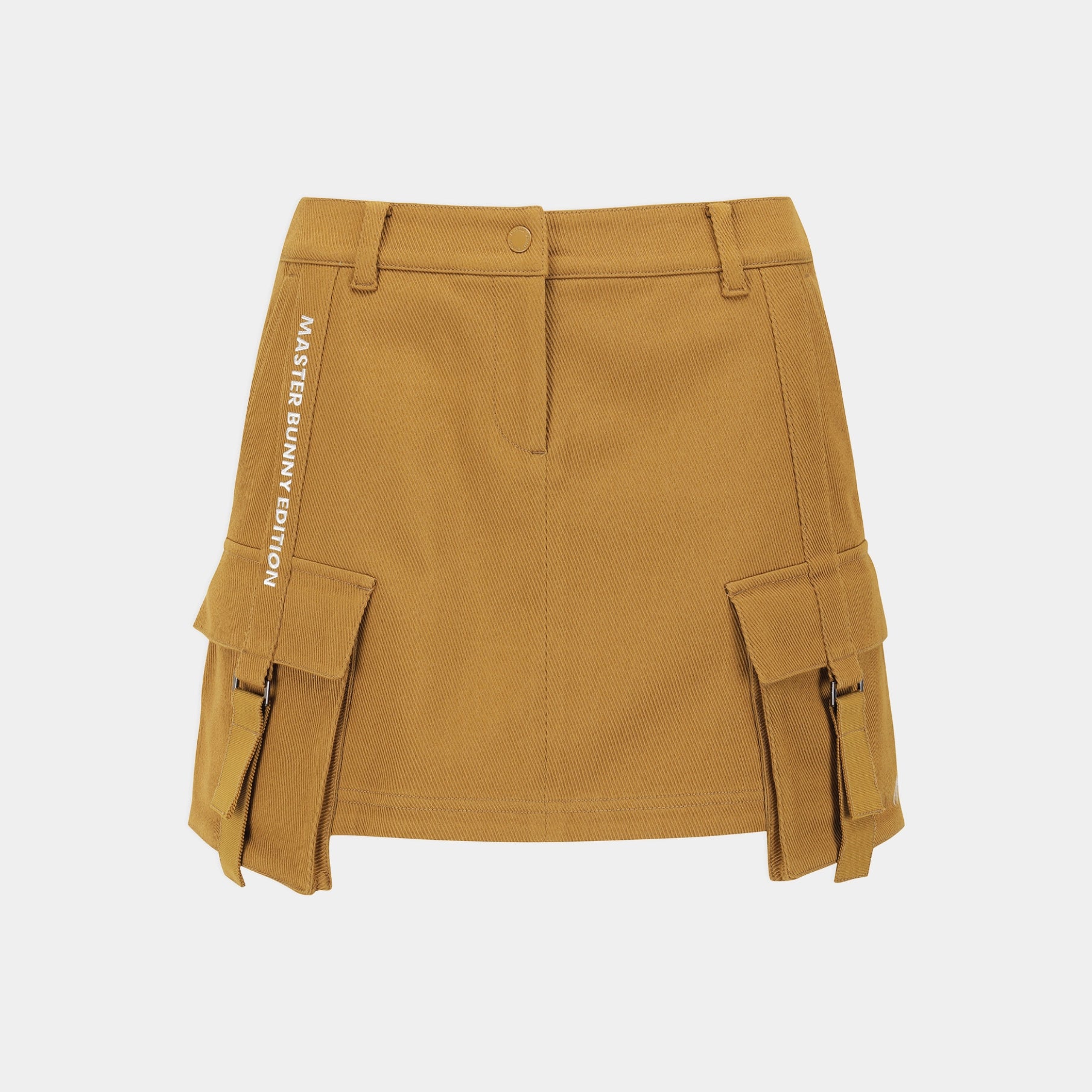 A mustard yellow cargo-style mini skirt with side flap pockets and vertical text reading 'MASTER BUNNY EDITION' on the left side, shown against a light gray background.