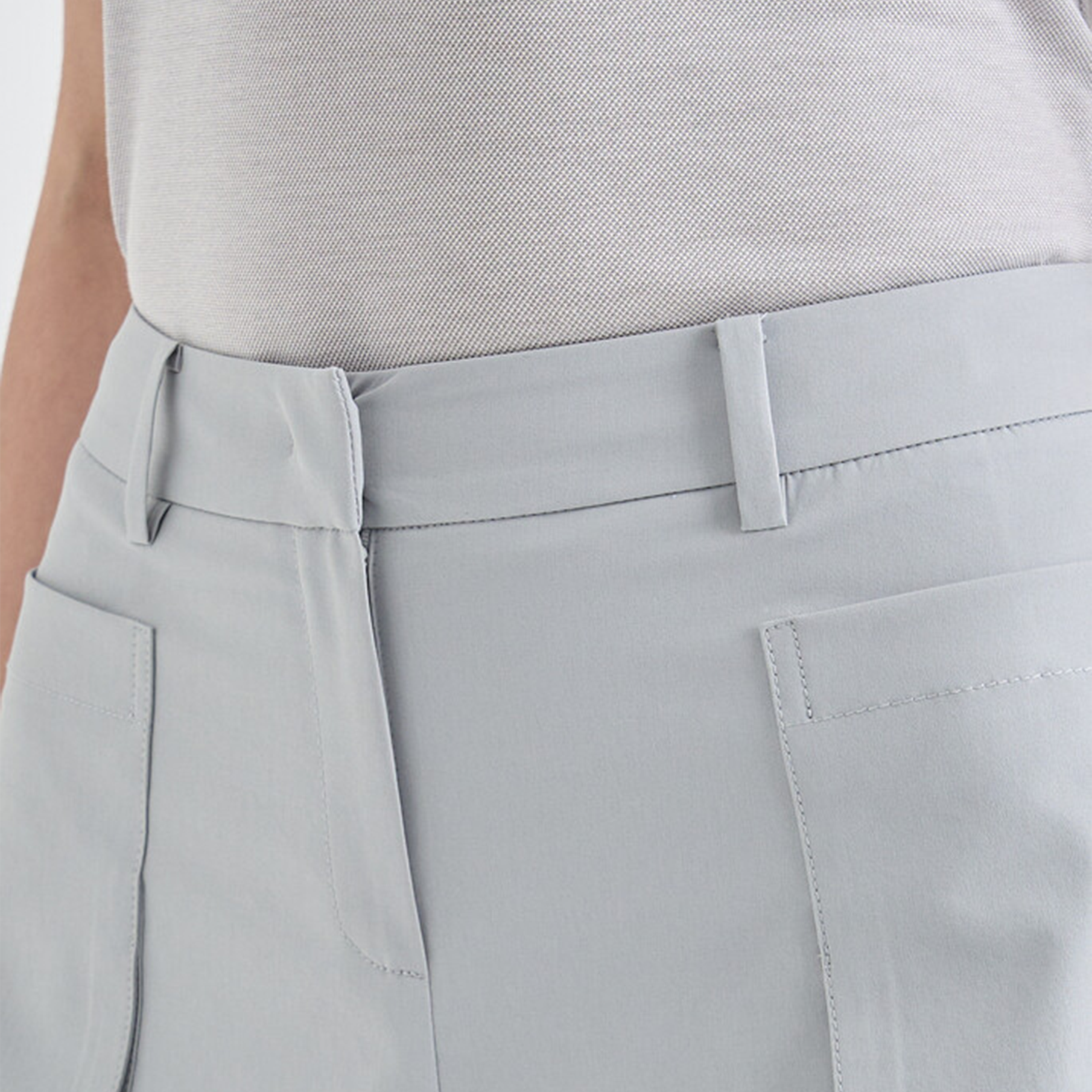 Close-up of light gray shorts and a white shirt.