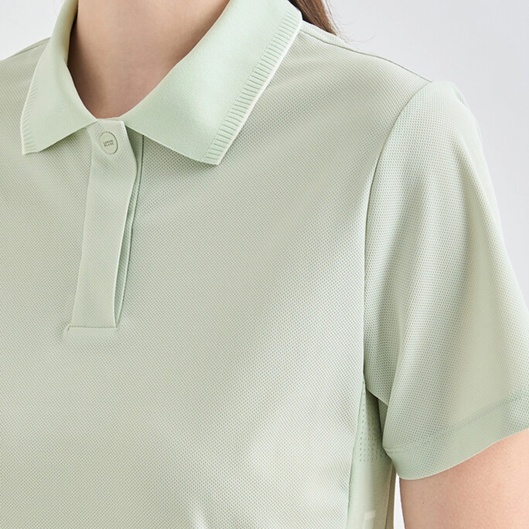 Light green polo shirt worn by a person on a white background