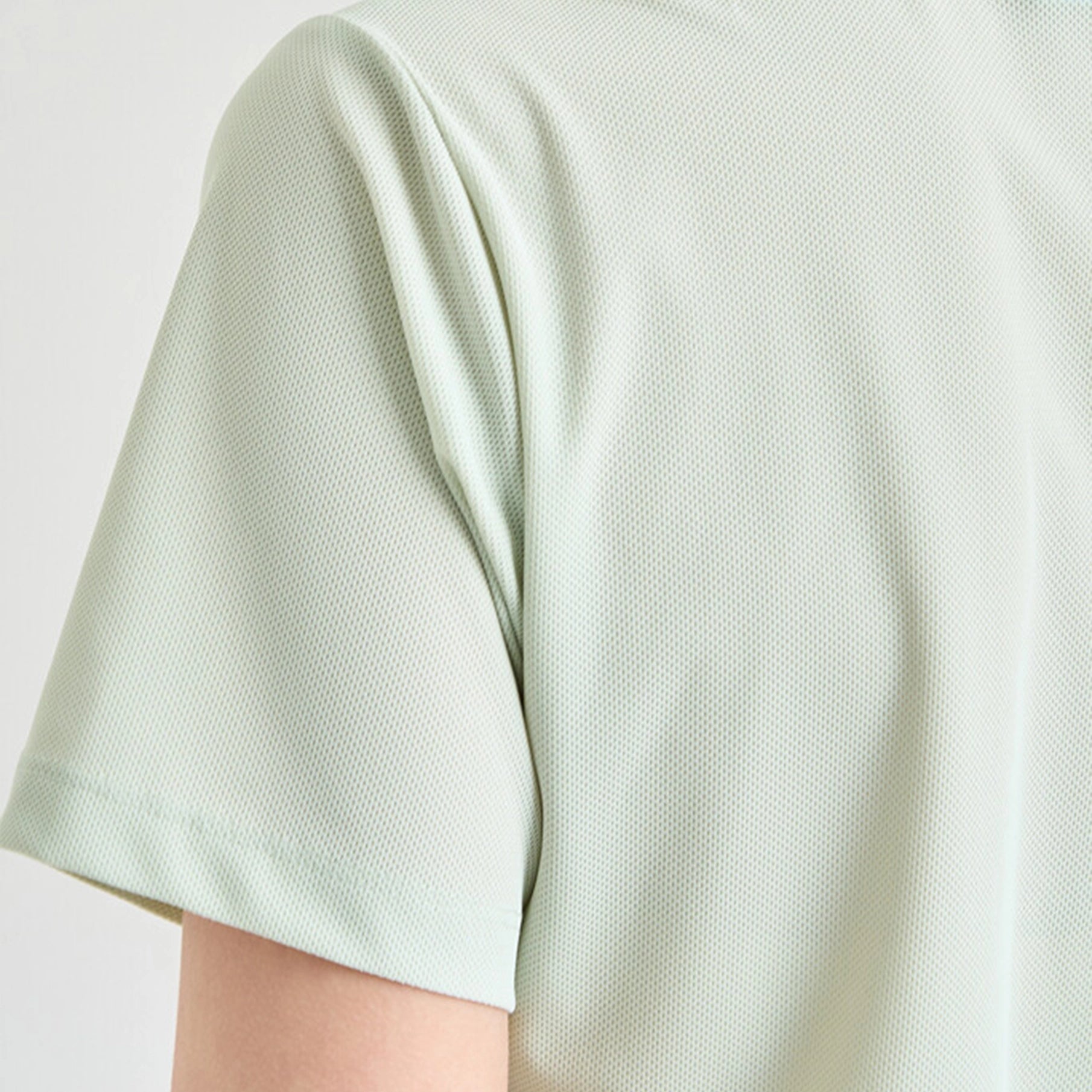Light green textured shirt on a plain background
