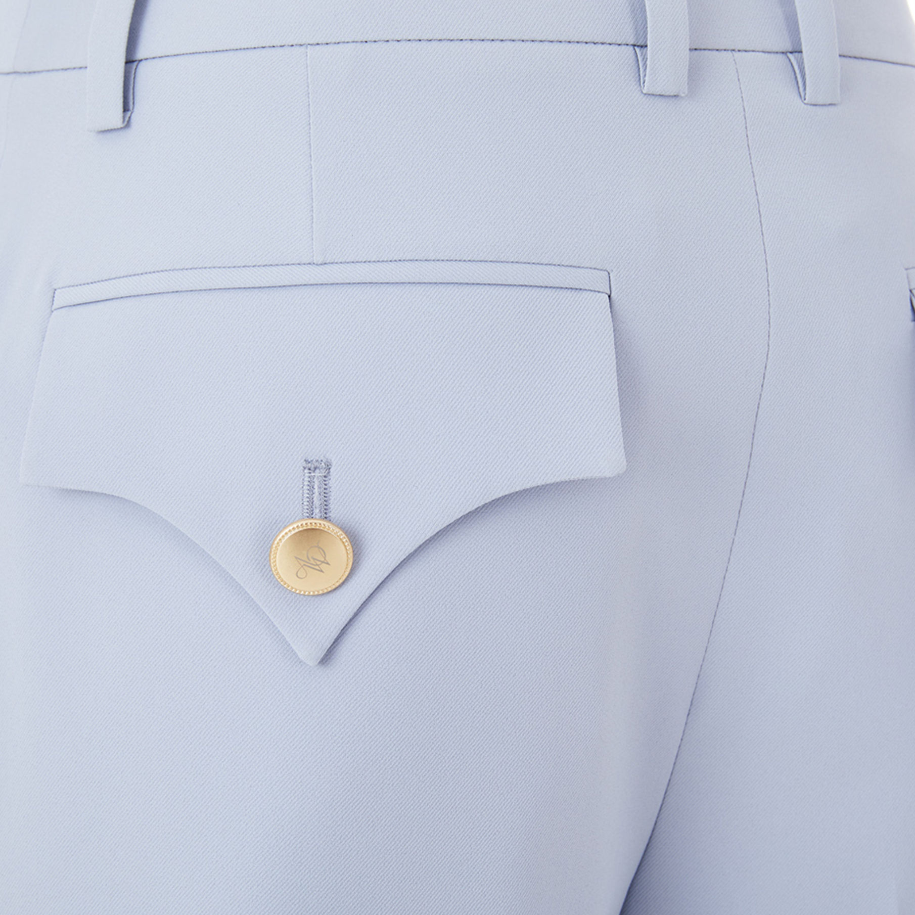 Light blue pants with a gold button on a matching pocket