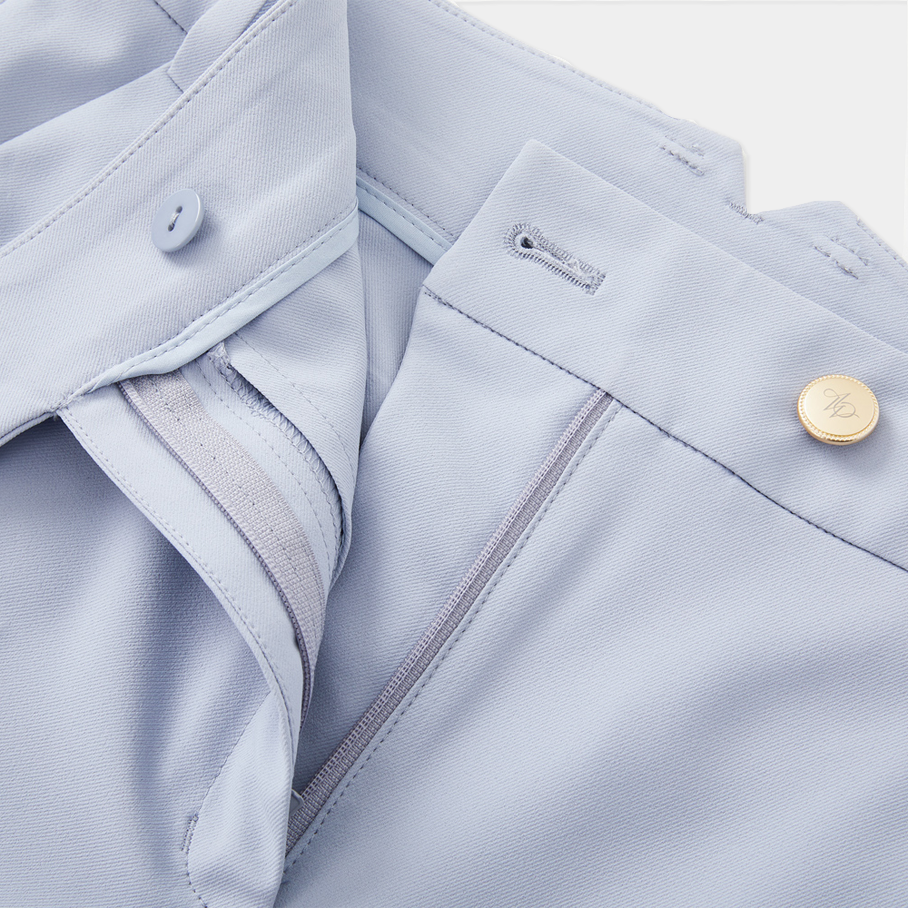 Close-up of light blue pants with a button and zipper detail on a white background