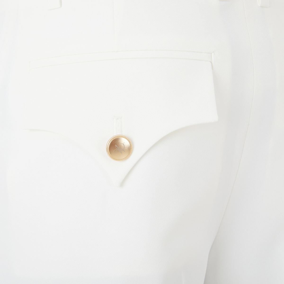 Gold button on a white short pocket