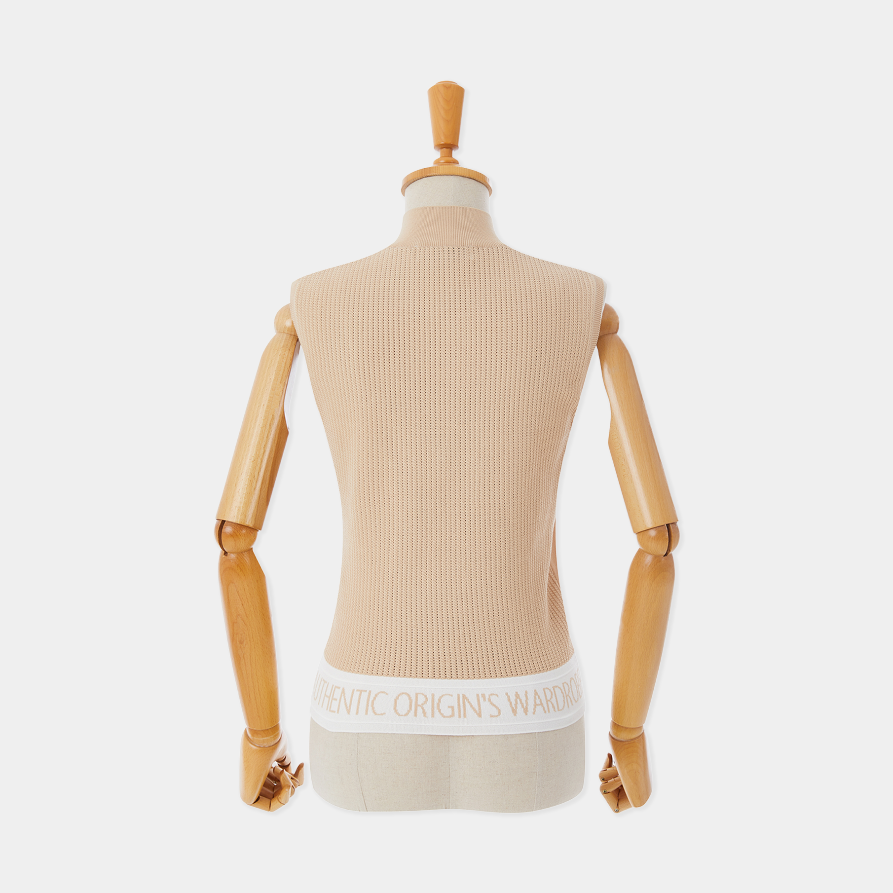 Mannequin wearing a beige ribbed sweater with a white waistband on a light gray background