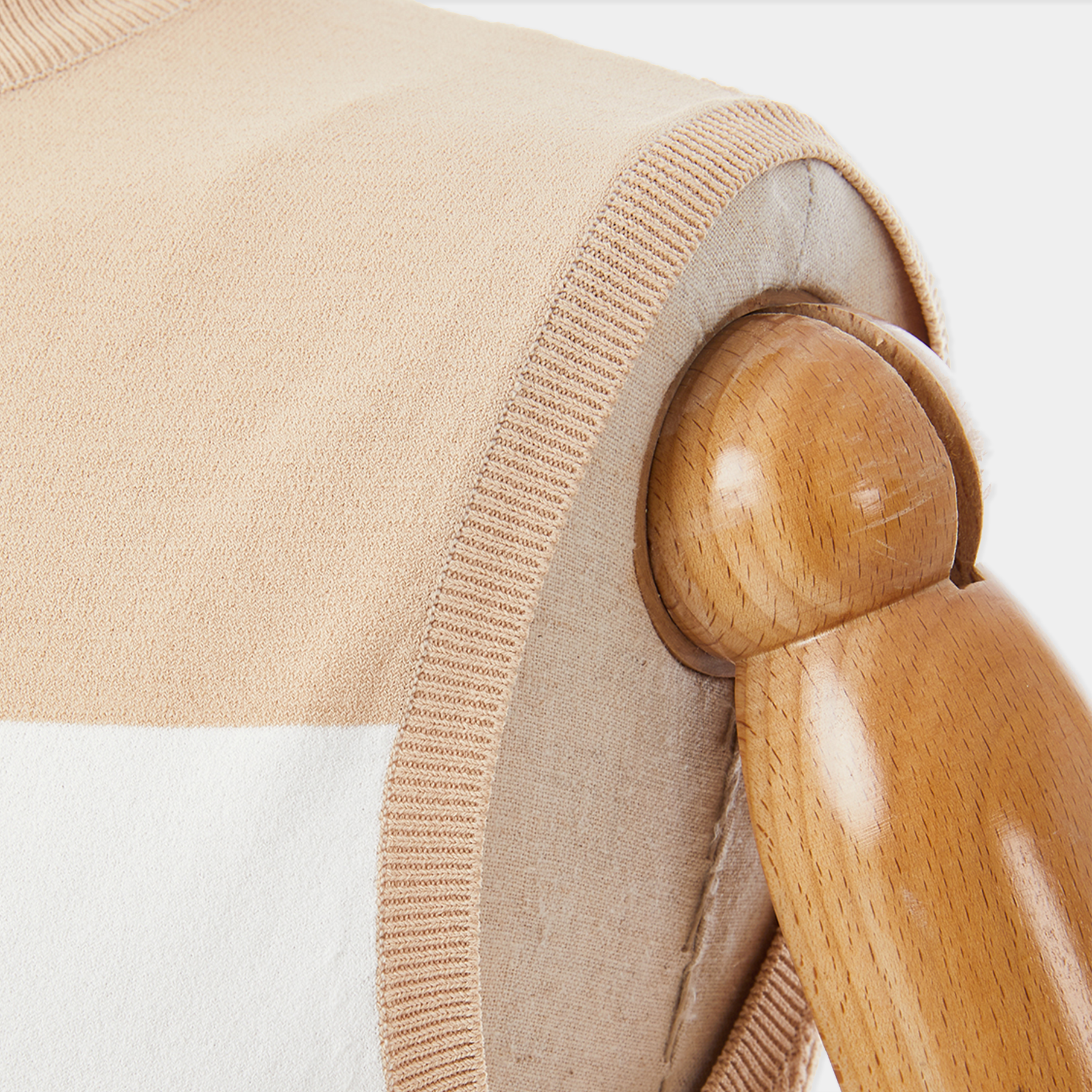 Close-up of a beige cushion with a wooden button on a white background