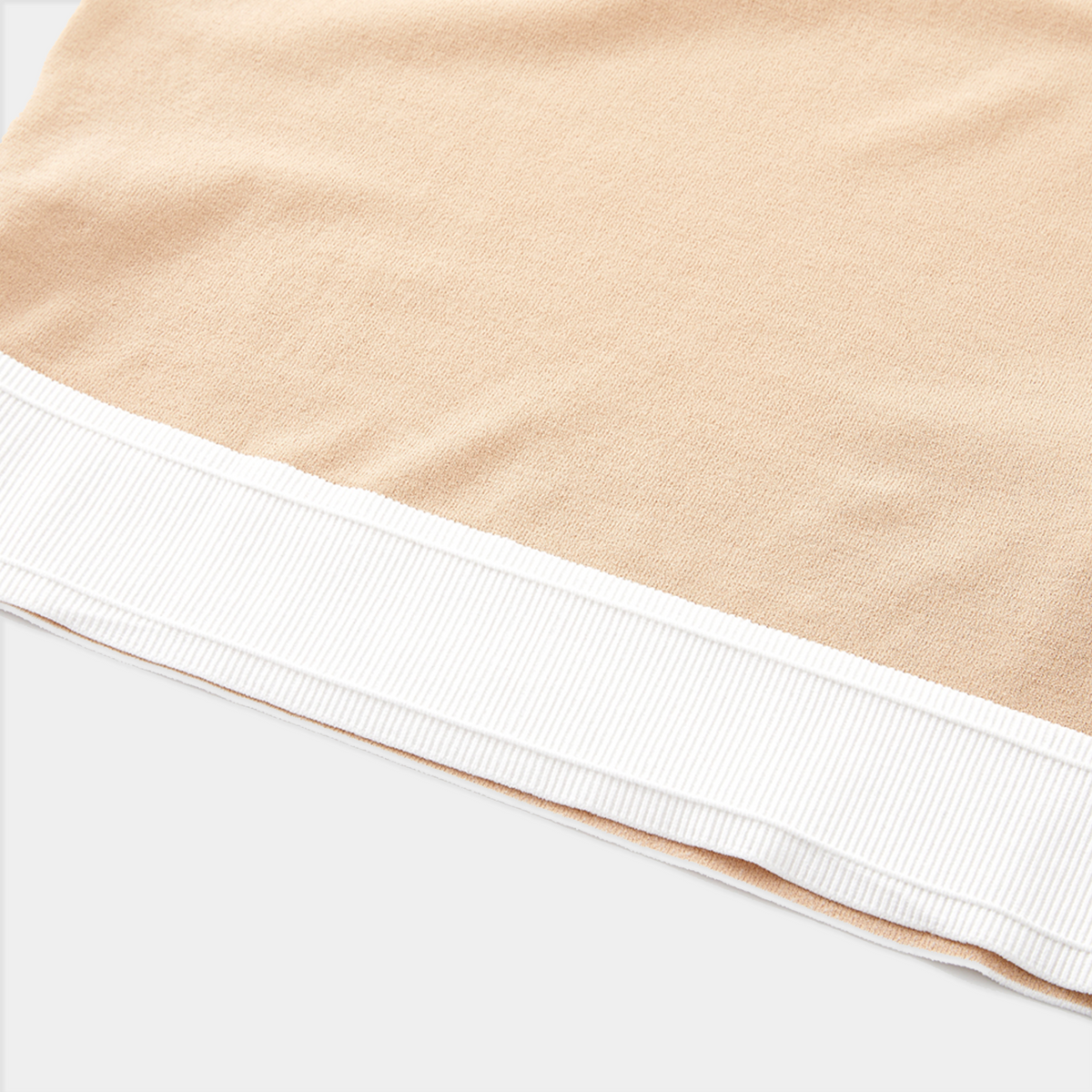 Close-up of beige fabric with white trim on a white background