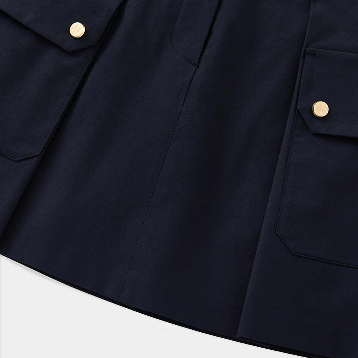Close-up of a navy blue skirt with button details on a white background