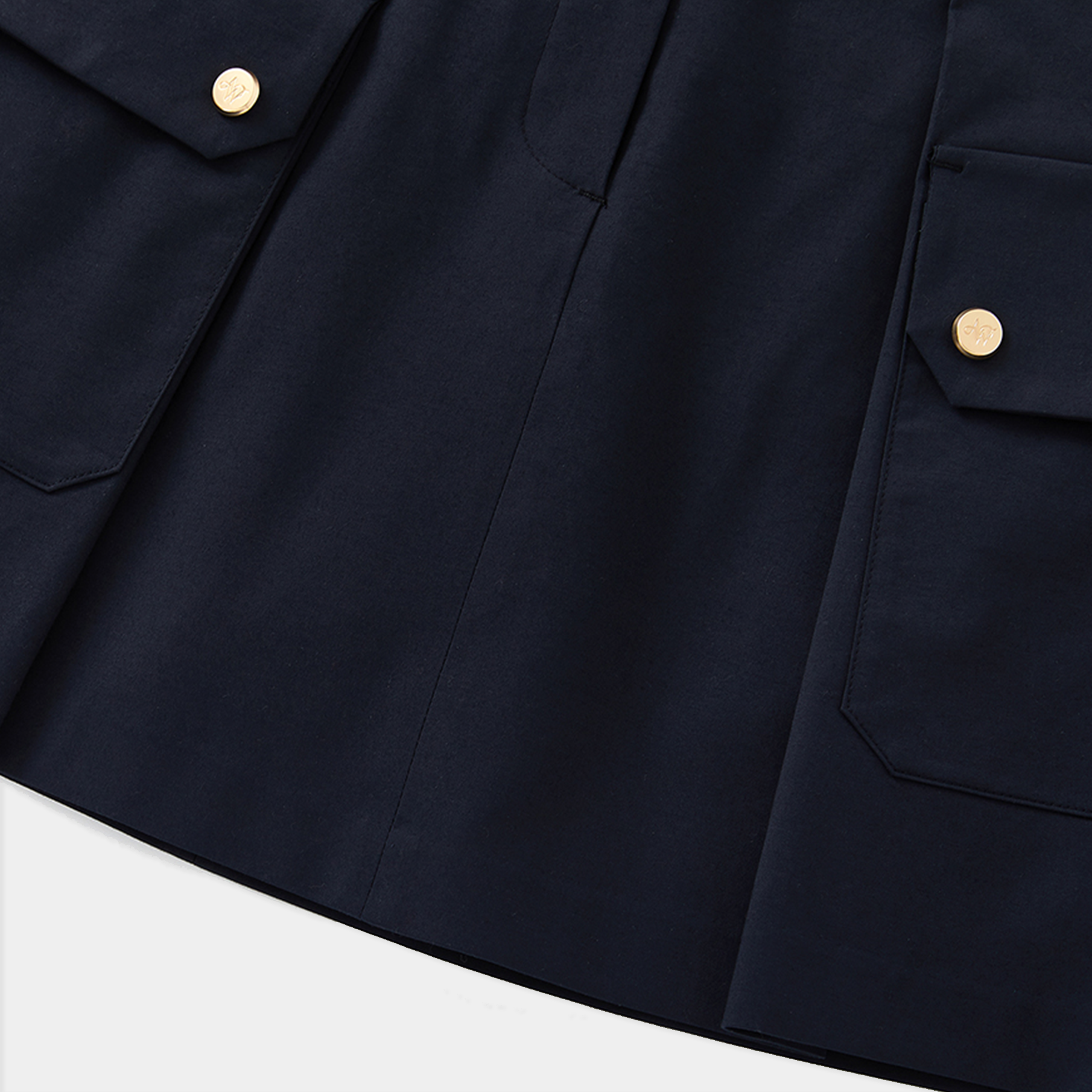 Close-up of a navy blue skirt with button details on a white background