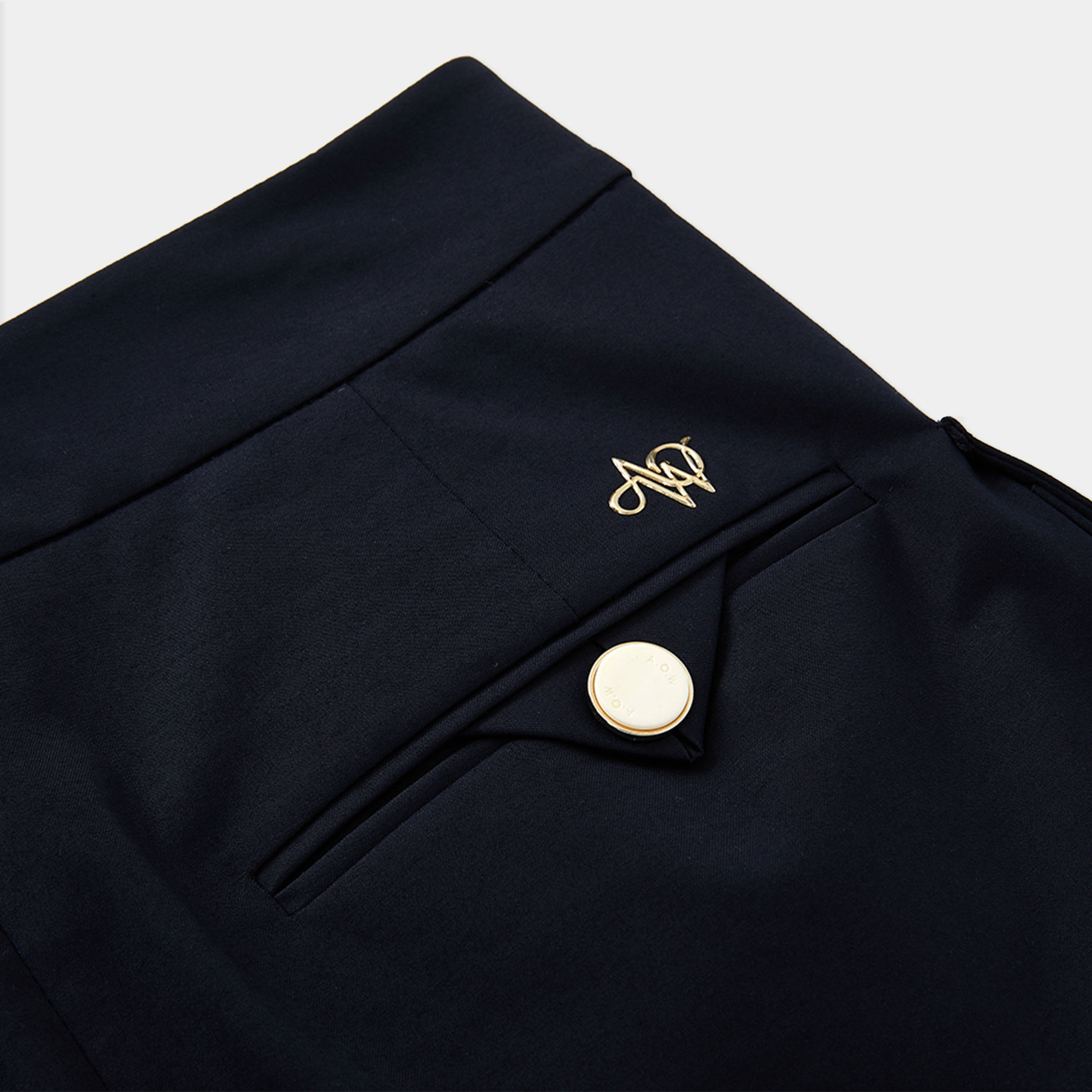 Navy blue skirt with a gold button and logo on a light gray background