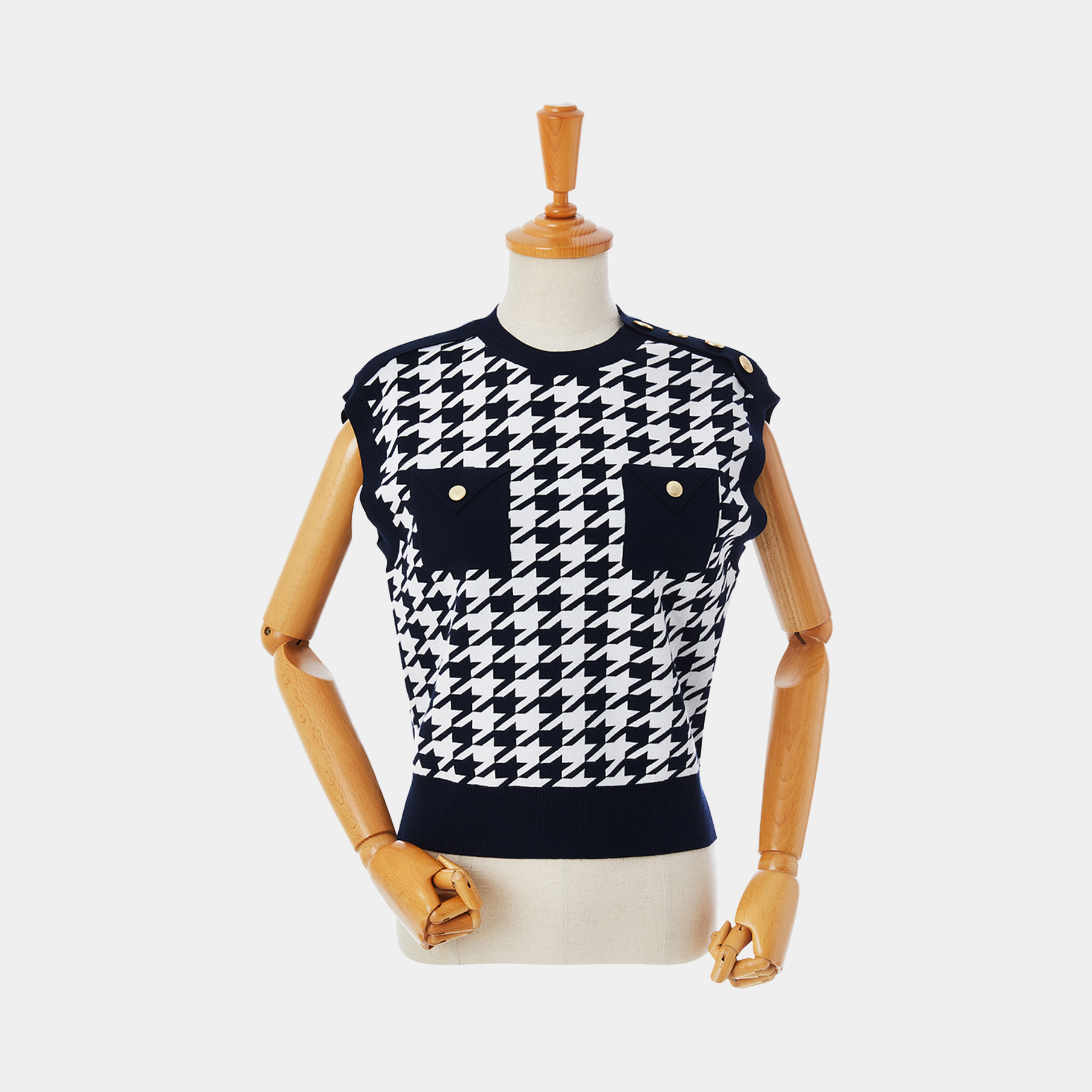 Navy and white houndstooth patterned sleeveless top on a wooden mannequin against a white background