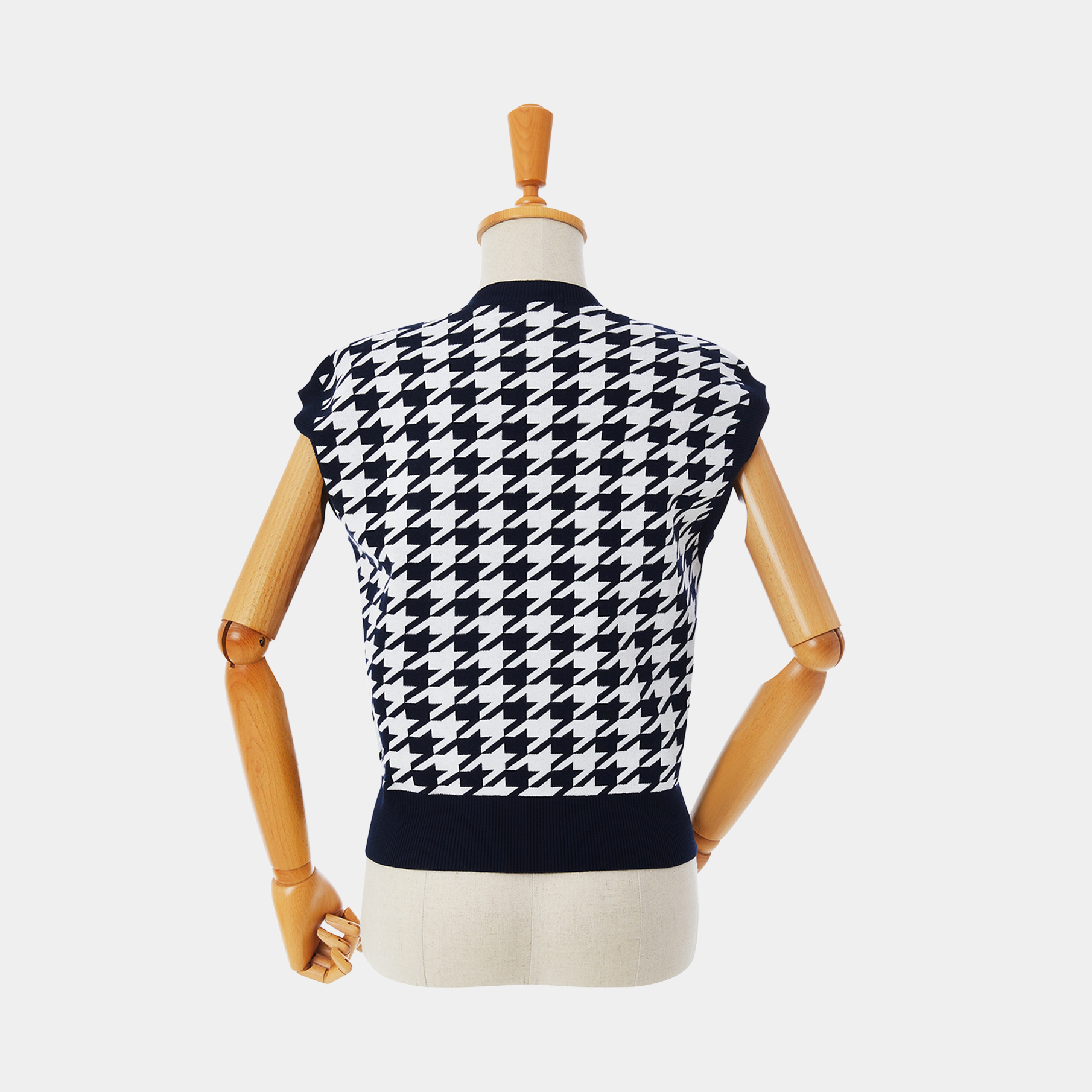 Navy and white houndstooth patterned sleeveless top on a mannequin against a white background