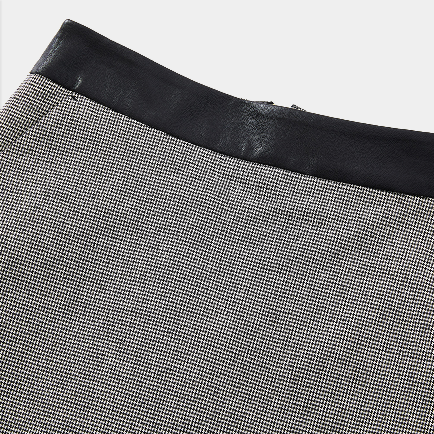Close-up of a skirt with black leather trim on a white background