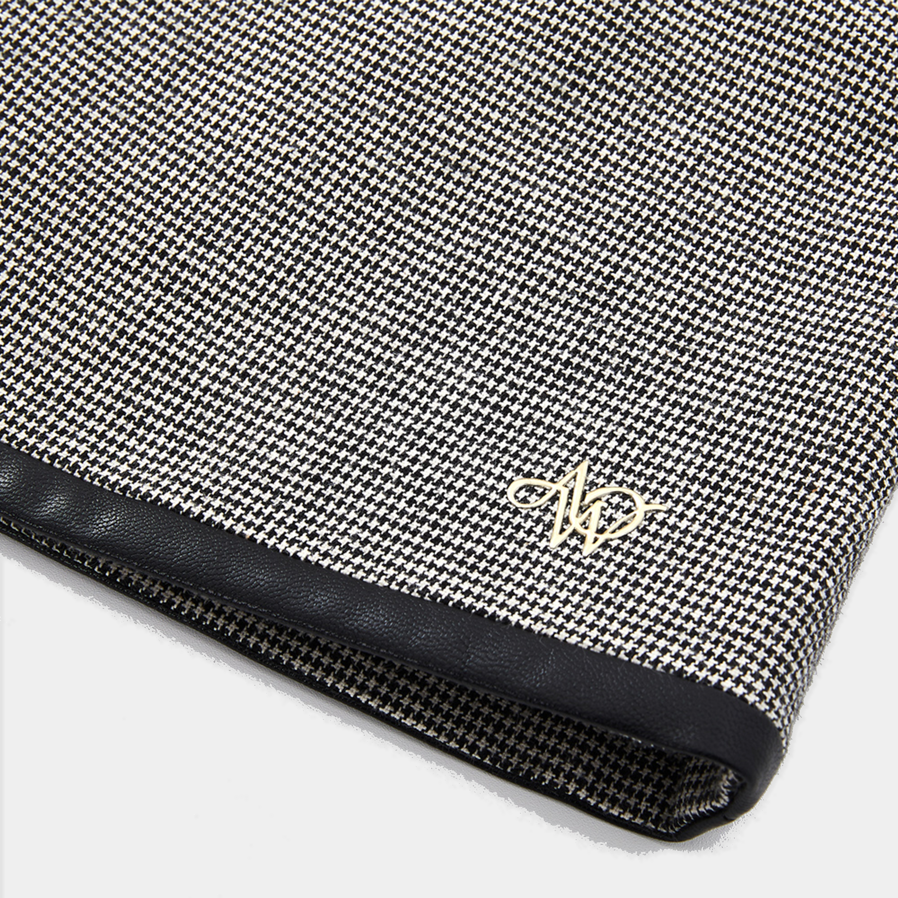 Close-up of a black and white patterned product with a gold logo on a white background