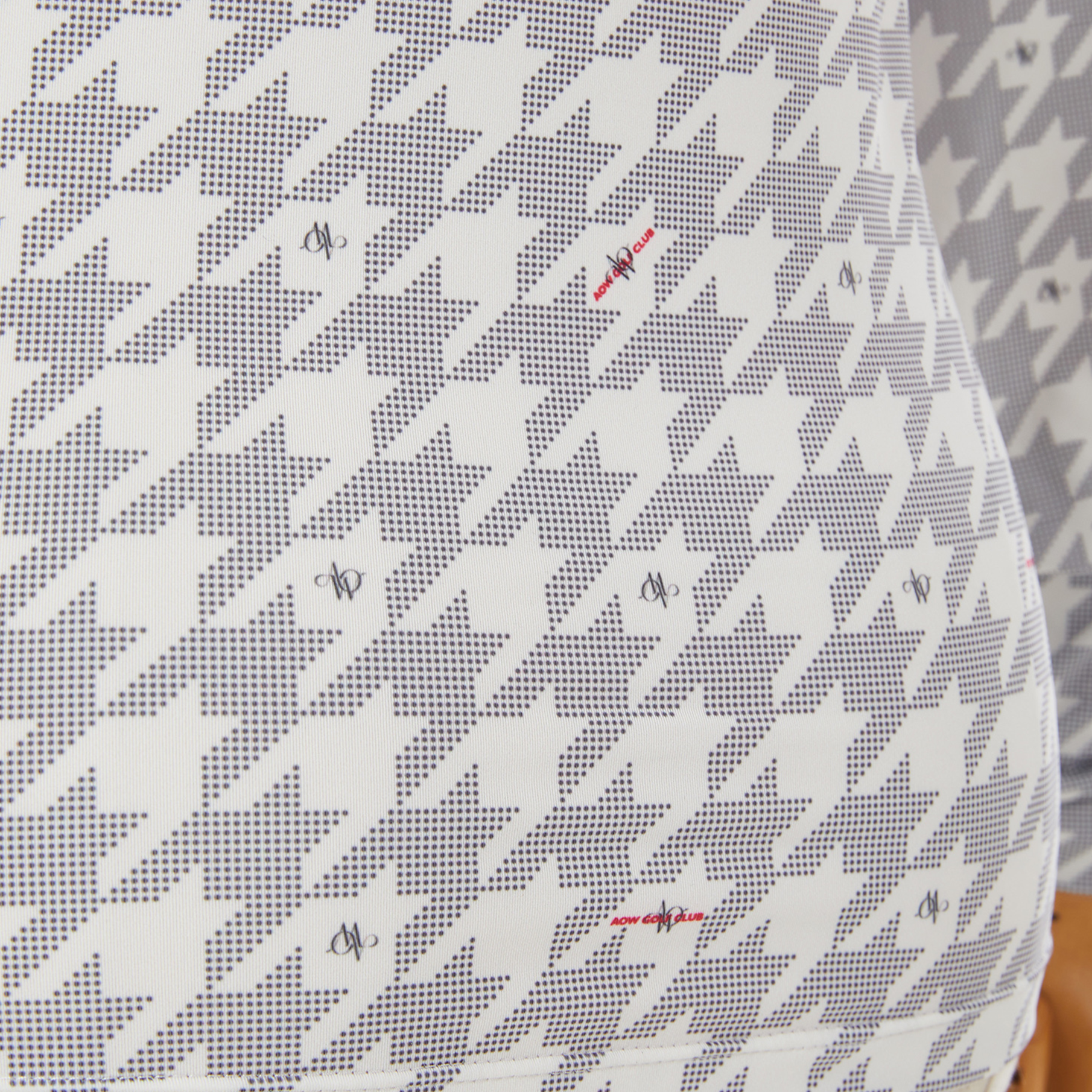 White fabric with black geometric pattern on a textured gray background