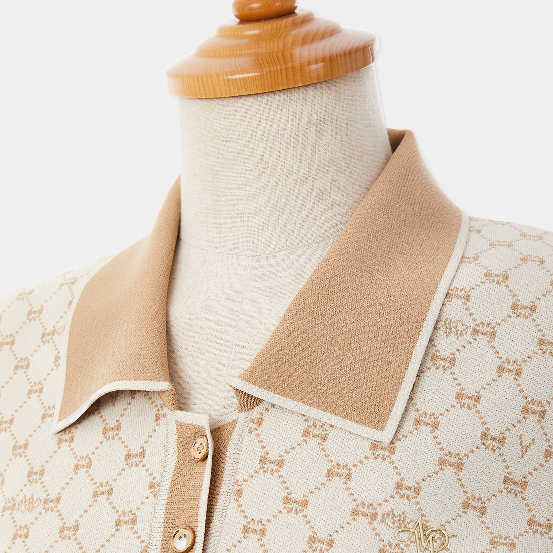Mannequin wearing a beige patterned shirt with a wooden base on a white background