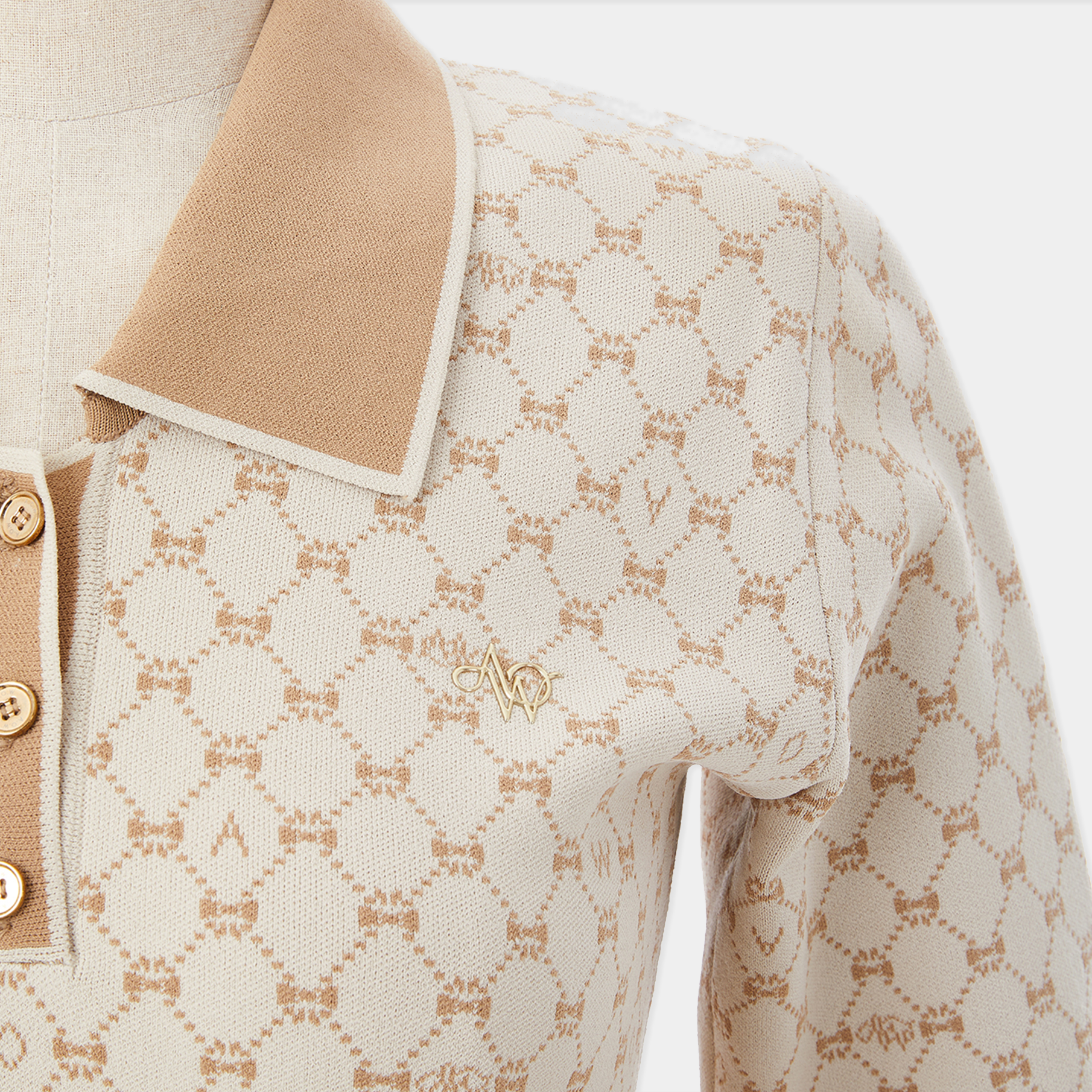 Close-up of a patterned fabric with a brand logo on a beige background