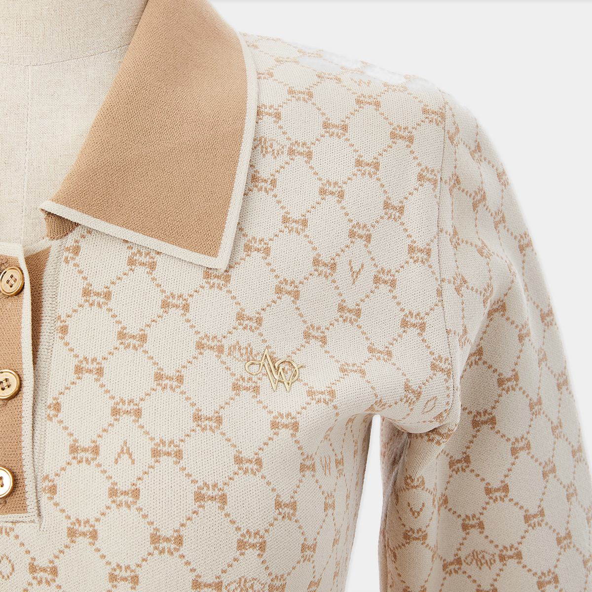 Close-up of a patterned fabric with a brand logo on a beige background
