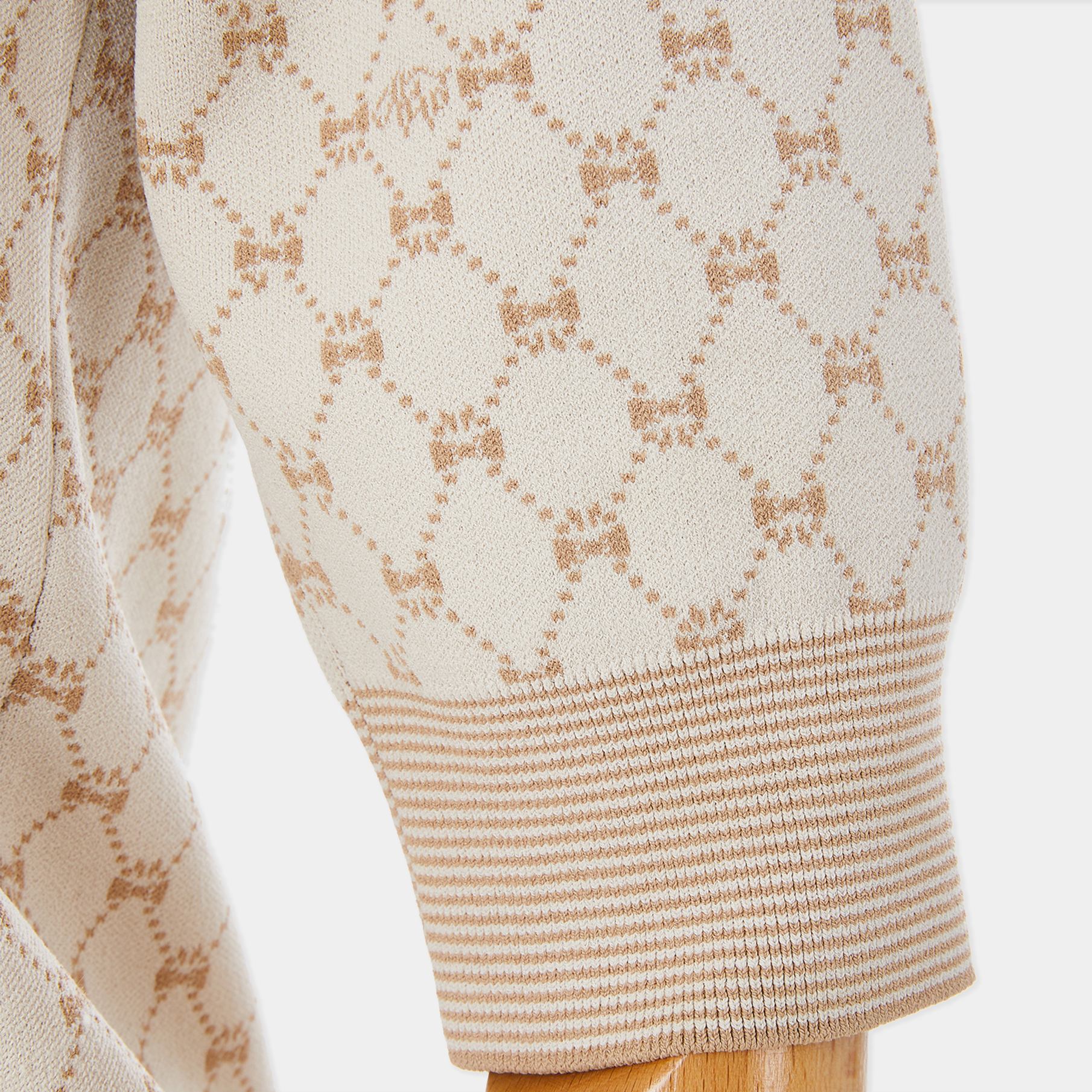 Close-up of a beige sweater with a subtle pattern on a white background