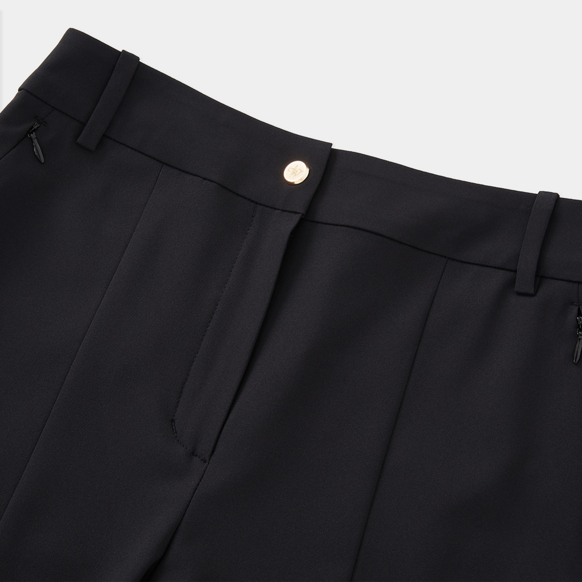 Close-up of black pants with a button on a light gray background