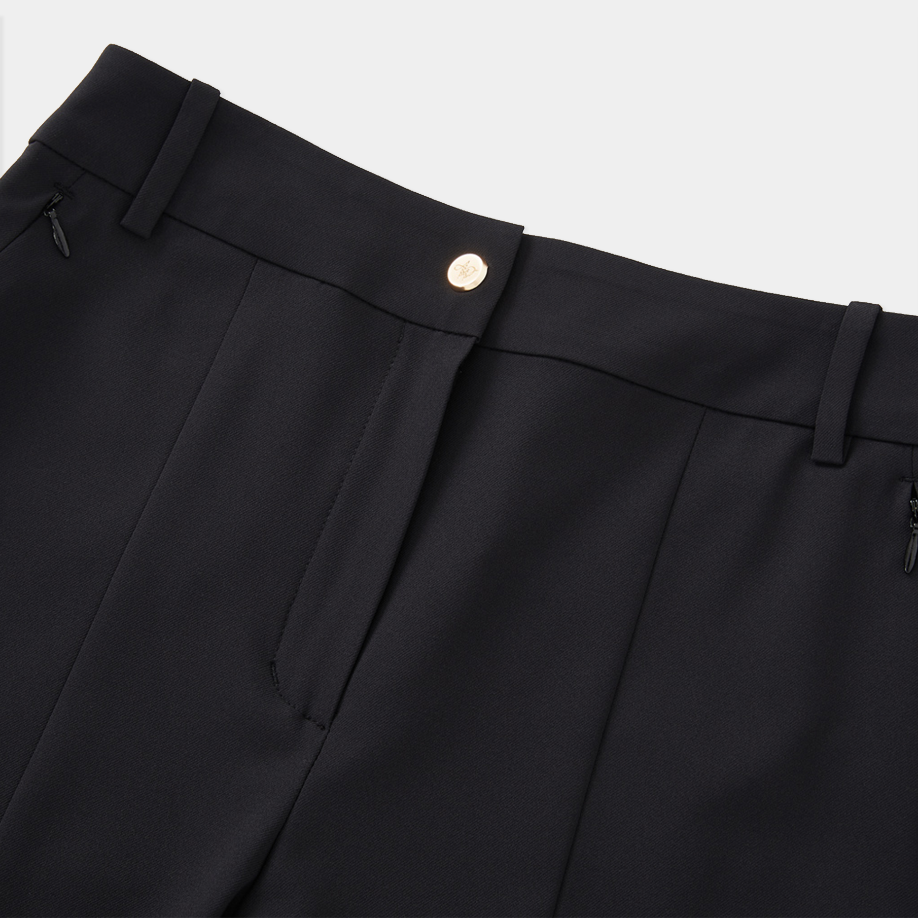Close-up of black pants with a button on a light gray background