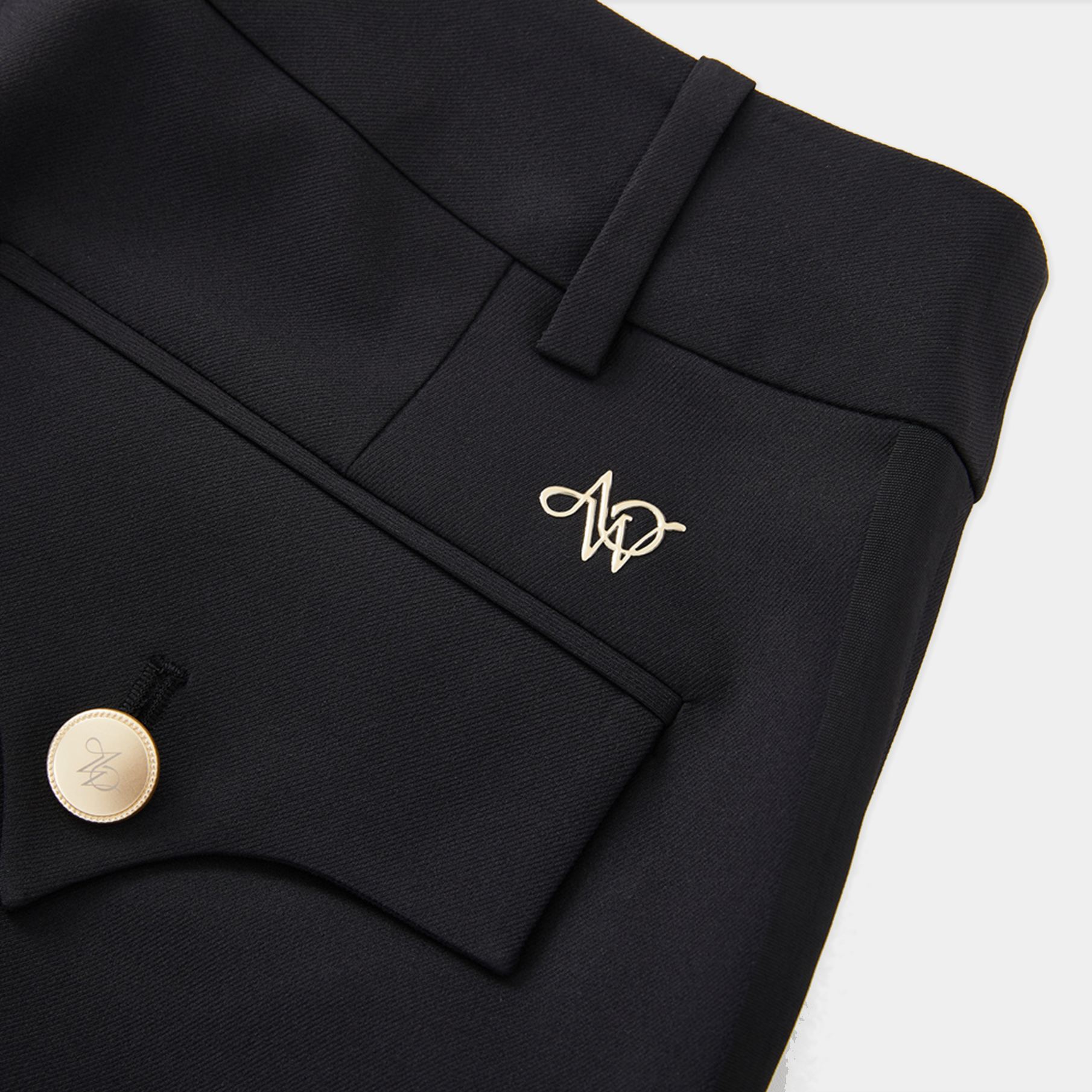Black pants with a gold emblem on a white background