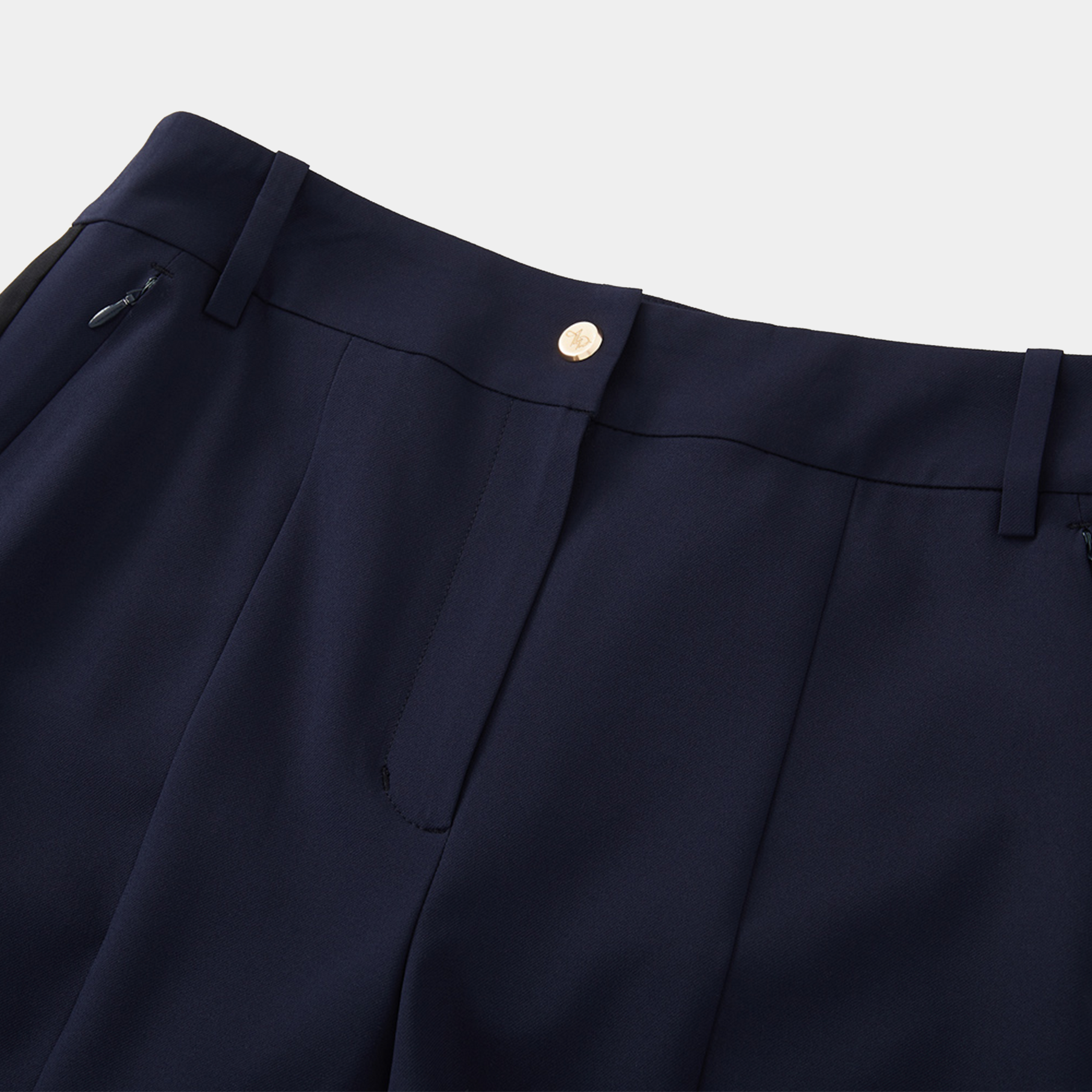 Close-up of navy blue pants with a button on a light gray background