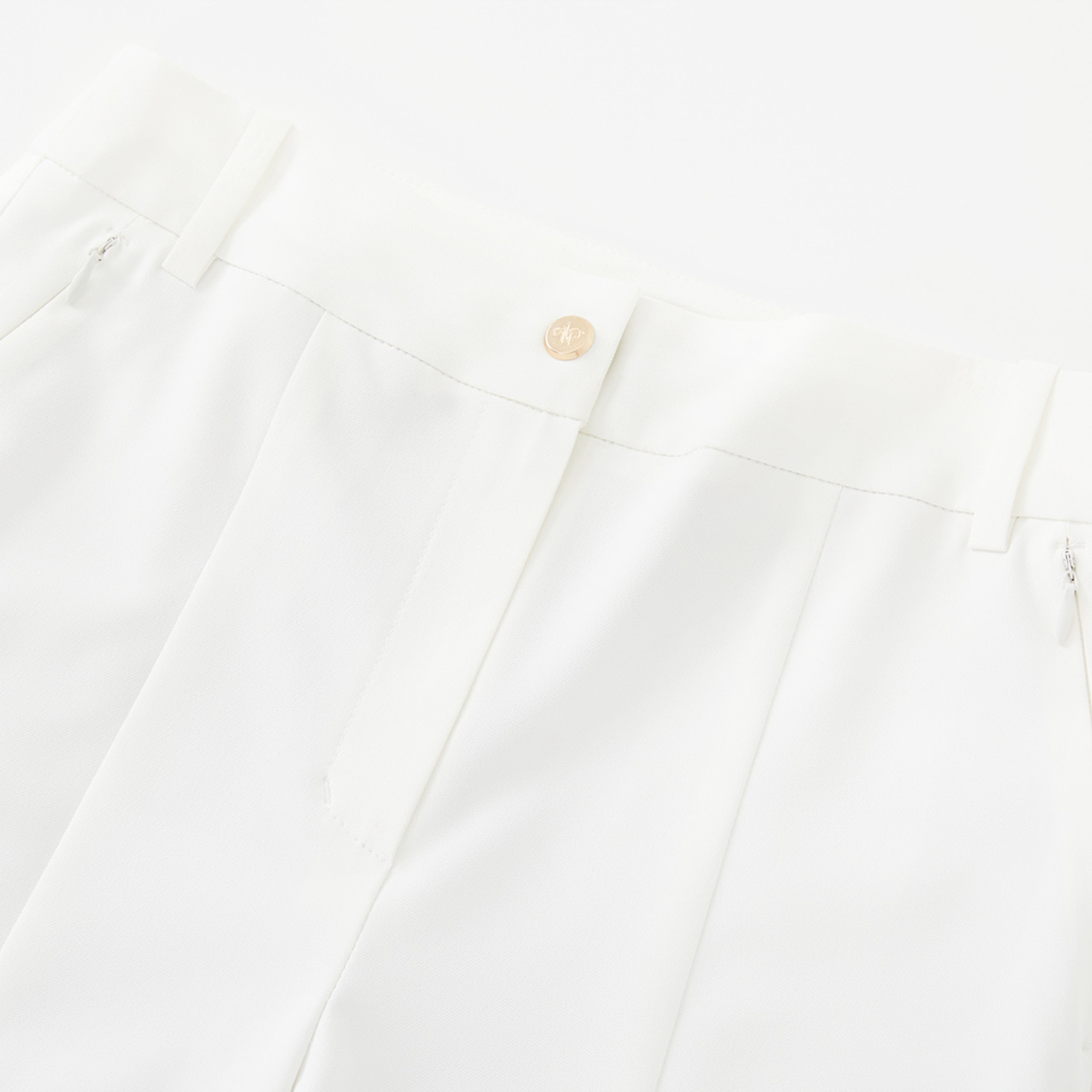 Close-up of a white pants with a button on a white background