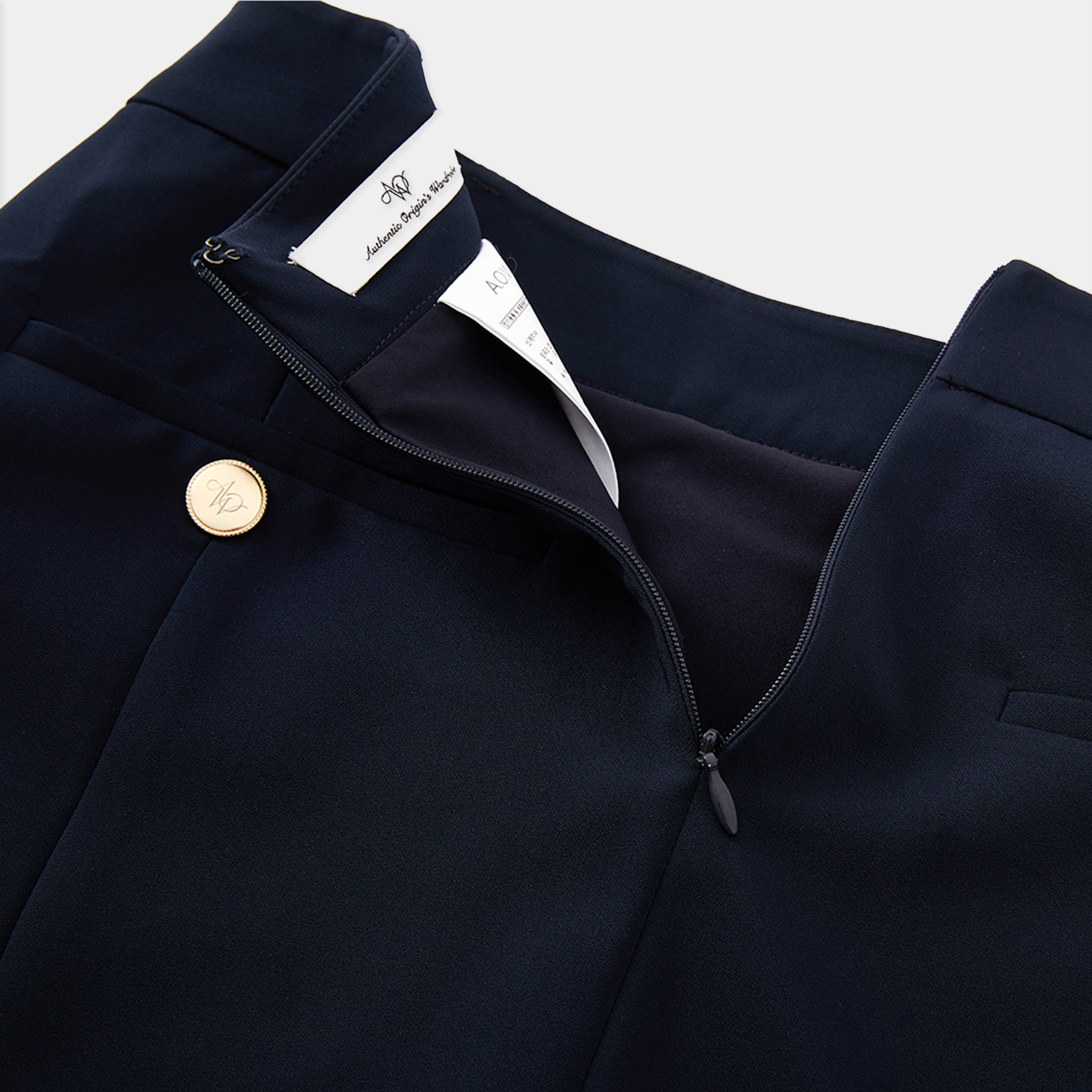 Navy blue skirt with a gold button and white label on a light gray background