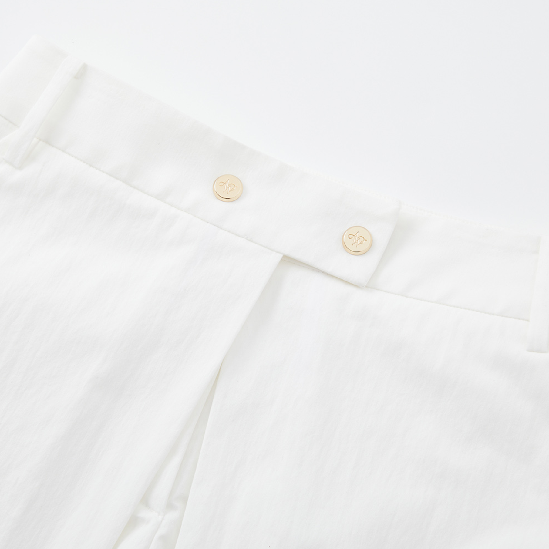 Close-up of a white shirt with gold buttons on a white background