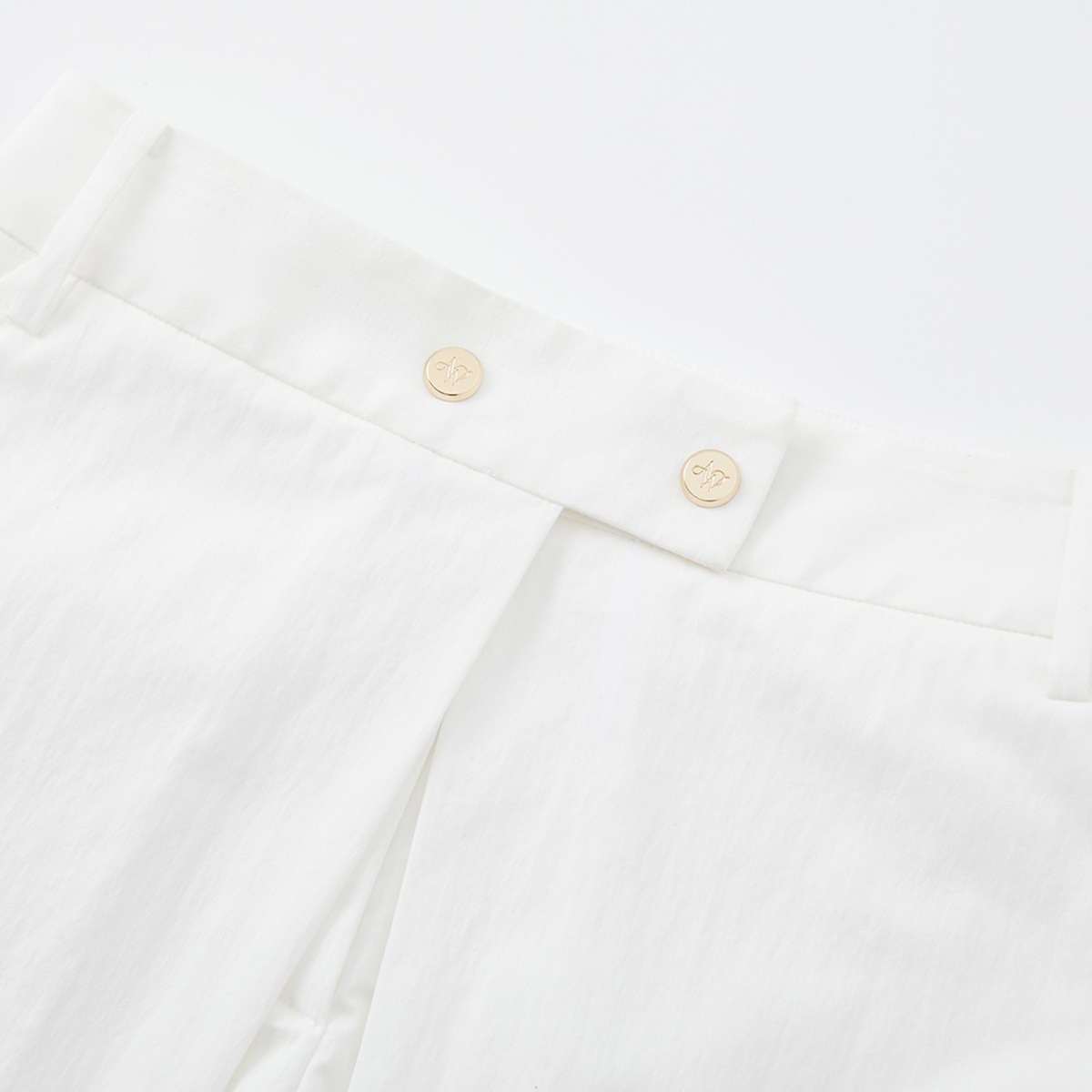 Close-up of a white shirt with gold buttons on a white background