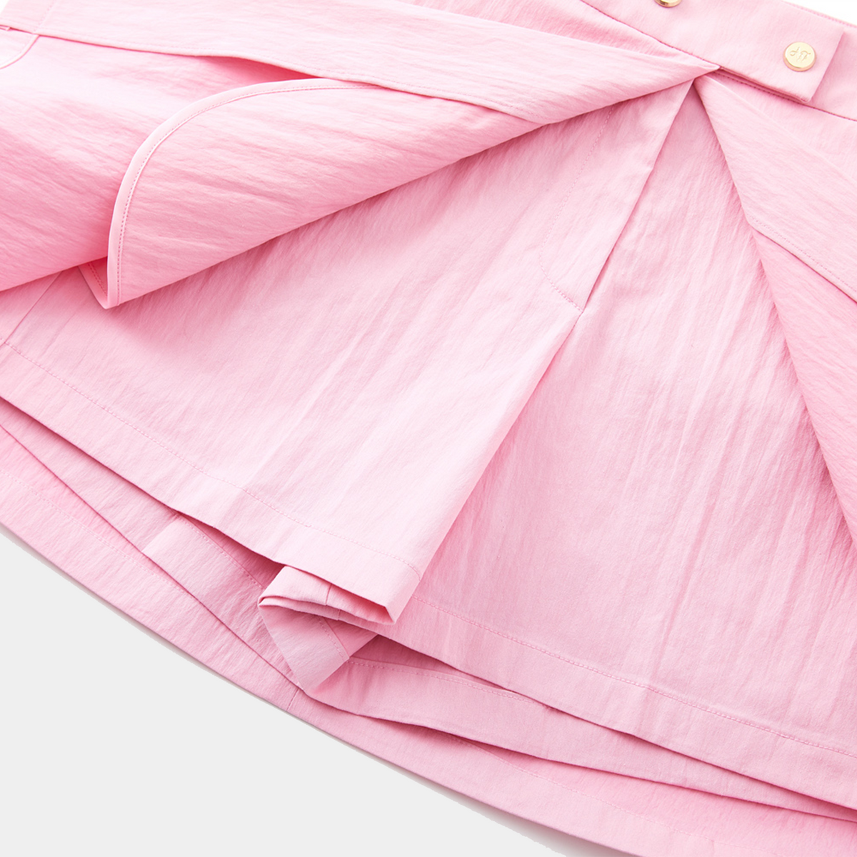 Close-up of a pink skirt with pleated details on a white background