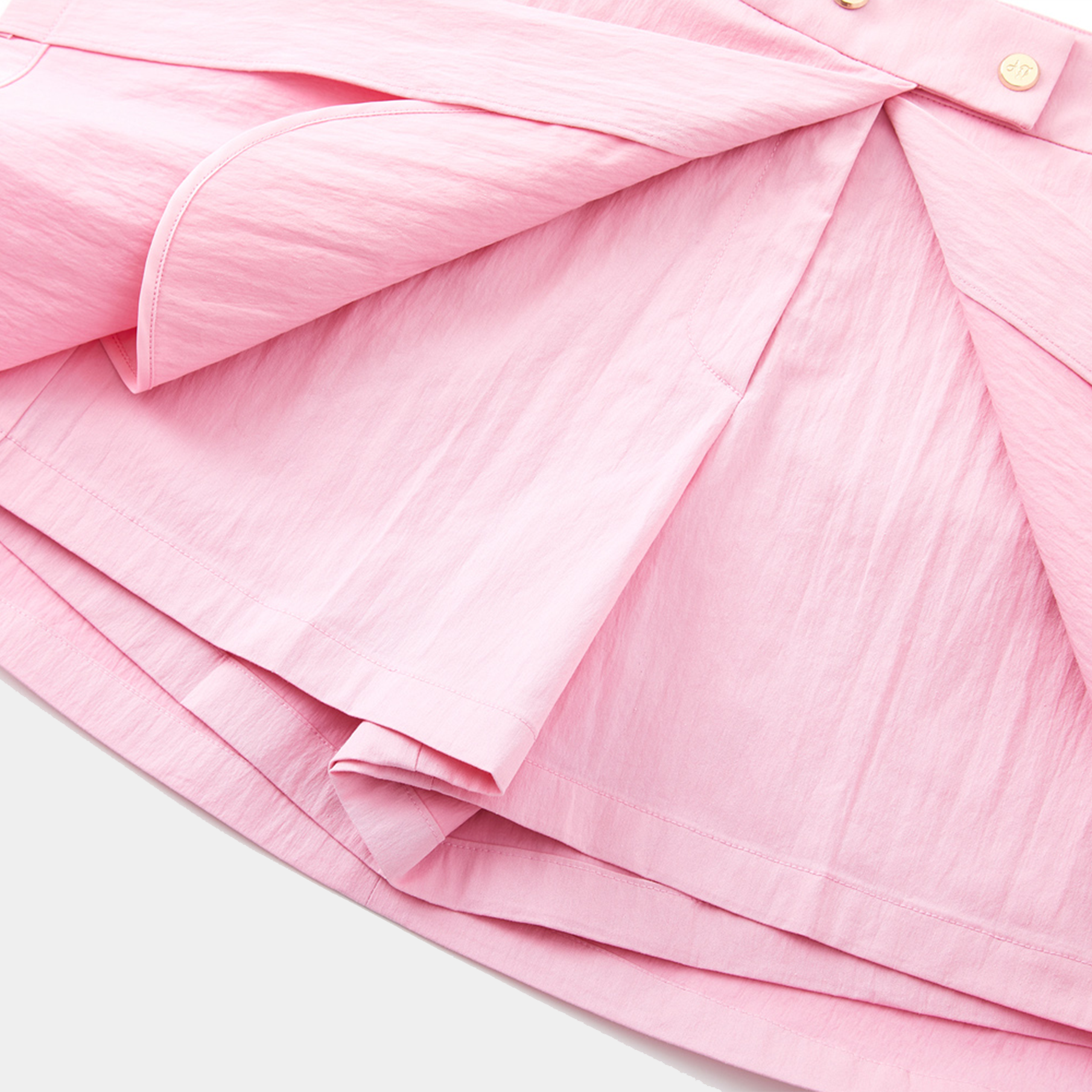 Close-up of a pink skirt with pleated details on a white background
