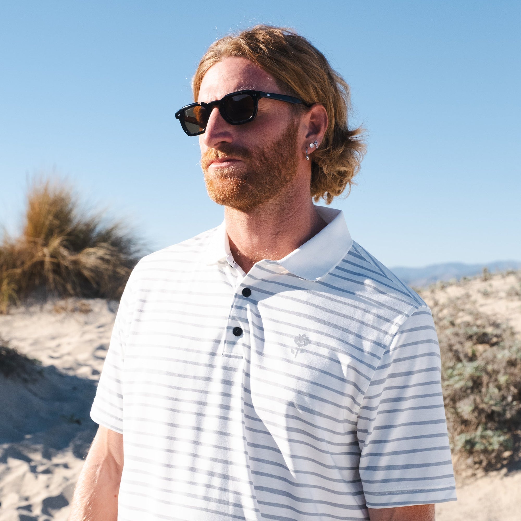 Man in glasses wearing Men's Striped Polo - White - Erthe Golf