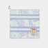 A square golf towel with a light blue and white striped pattern, featuring a botanical print and a &
