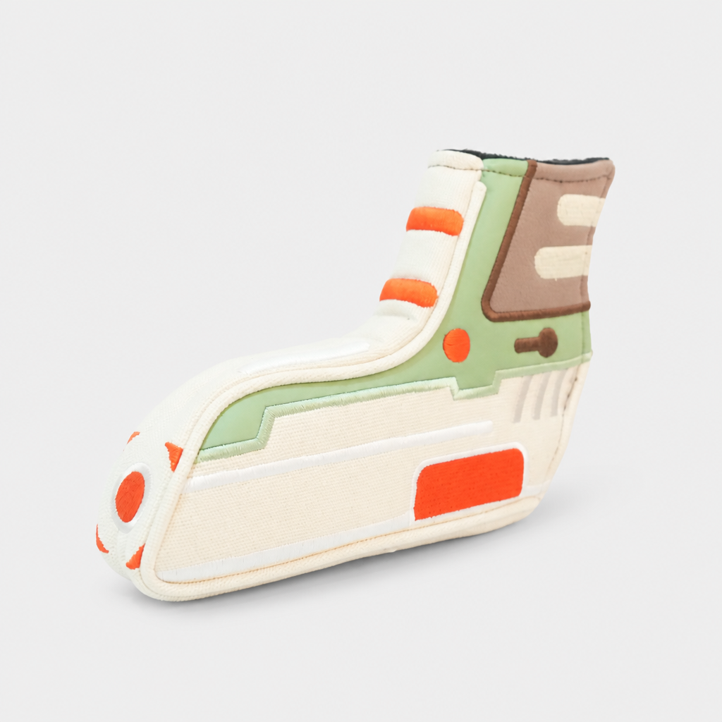 A novelty blade putter cover with a retro sci-fi design, featuring cream, sage green, orange, and brown panels on a light gray background.