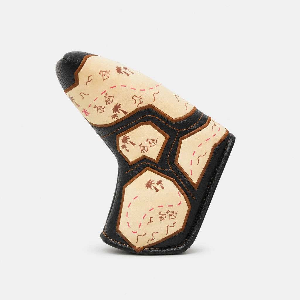 A golf club headcover with a Native American-inspired map design, featuring cream panels with brown and red illustrations of a compass, stars, and palm trees, bordered by black leather-like trim, shown on a light gray background.
