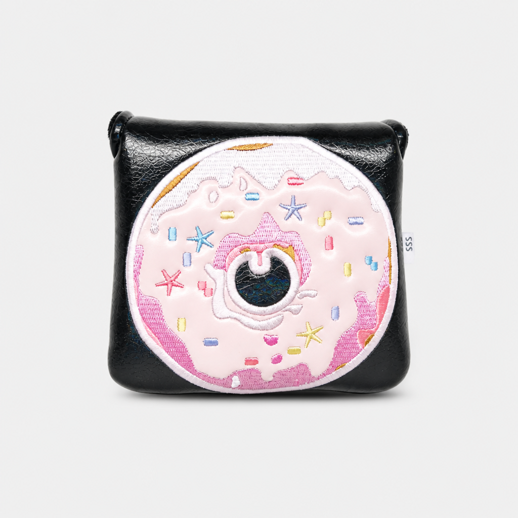 A black leather mallet putter cover featuring a large, detailed embroidered donut design on the front. The donut has light pink frosting, colorful embroidered sprinkles, and a dark center.