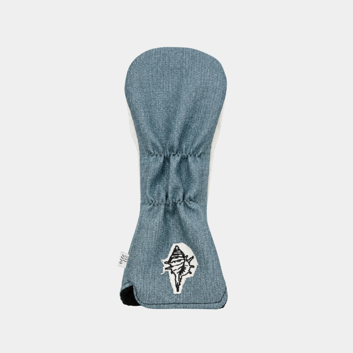 A blue denim hybrid cover shown flat against a light gray background, featuring a white embroidered logo of a stylized bird on the lower front.