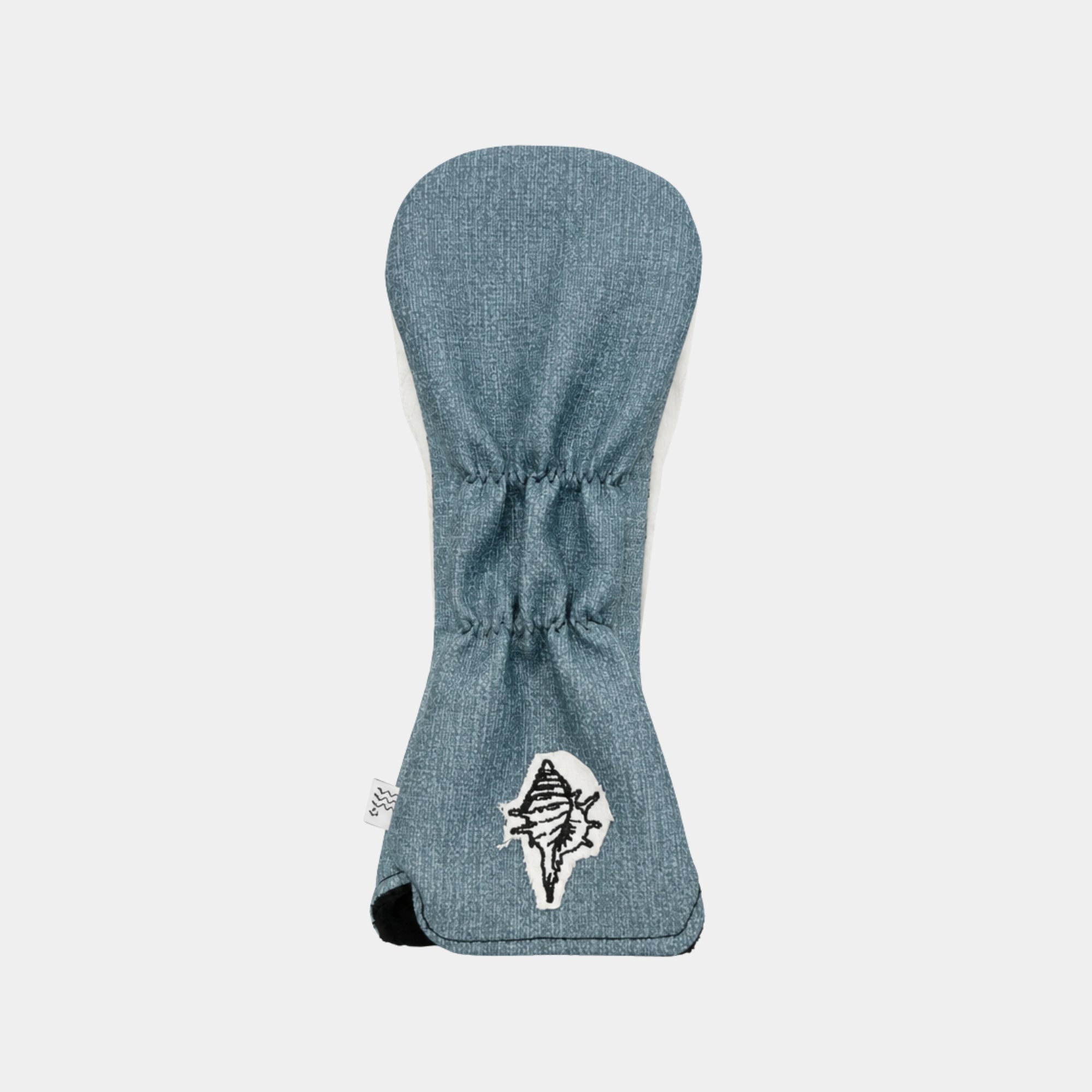 A blue denim hybrid cover shown flat against a light gray background, featuring a white embroidered logo of a stylized bird on the lower front.