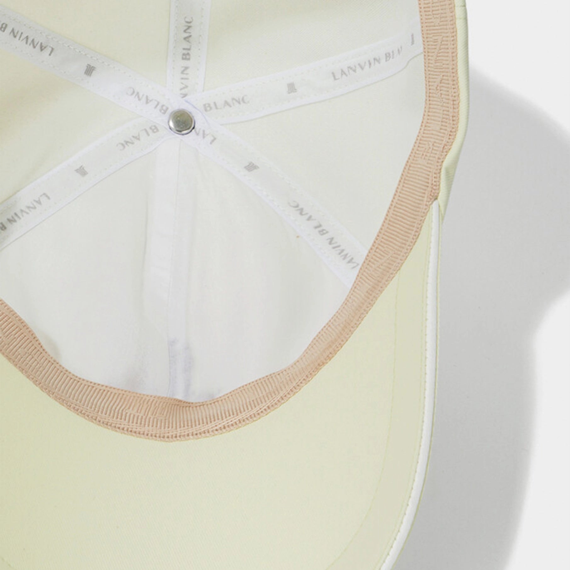 Close-up of a light-colored bra with visible brand name on a white background
