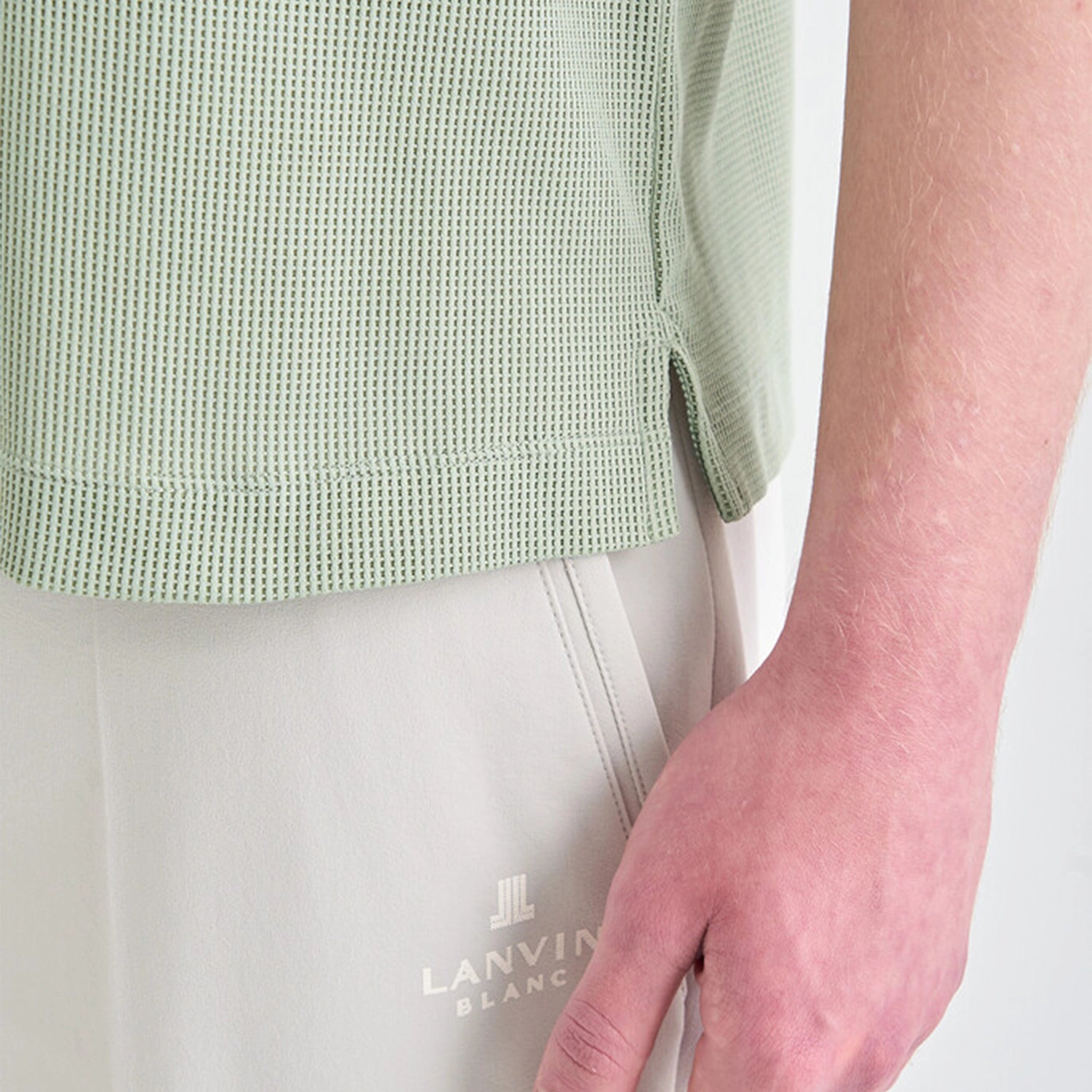 Person wearing a light green textured shirt and light gray pants with 'LANVIN' branding.