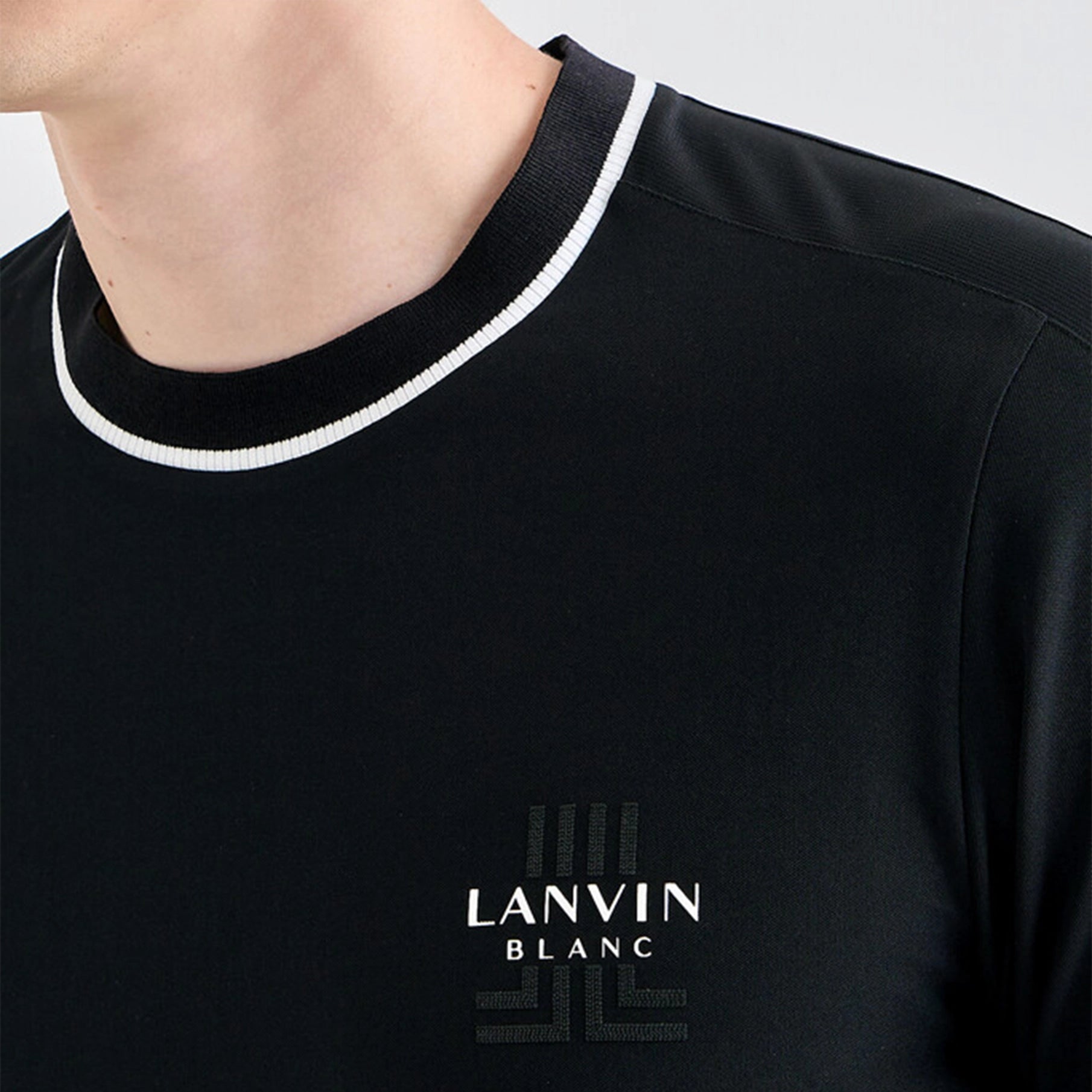 Black shirt with white trim and 'LANVIN BLANC' logo on a plain background
