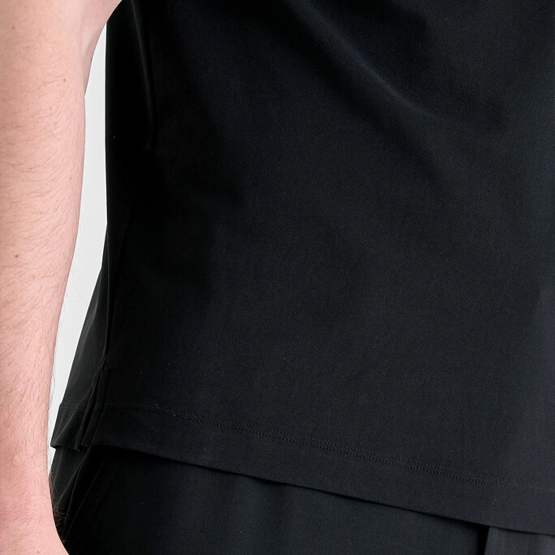 Close-up of a person wearing a black outfit with a plain background