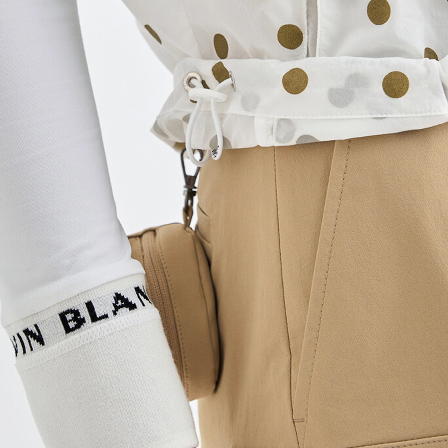 Close-up of the drawstring in the white vest with gold polka dots