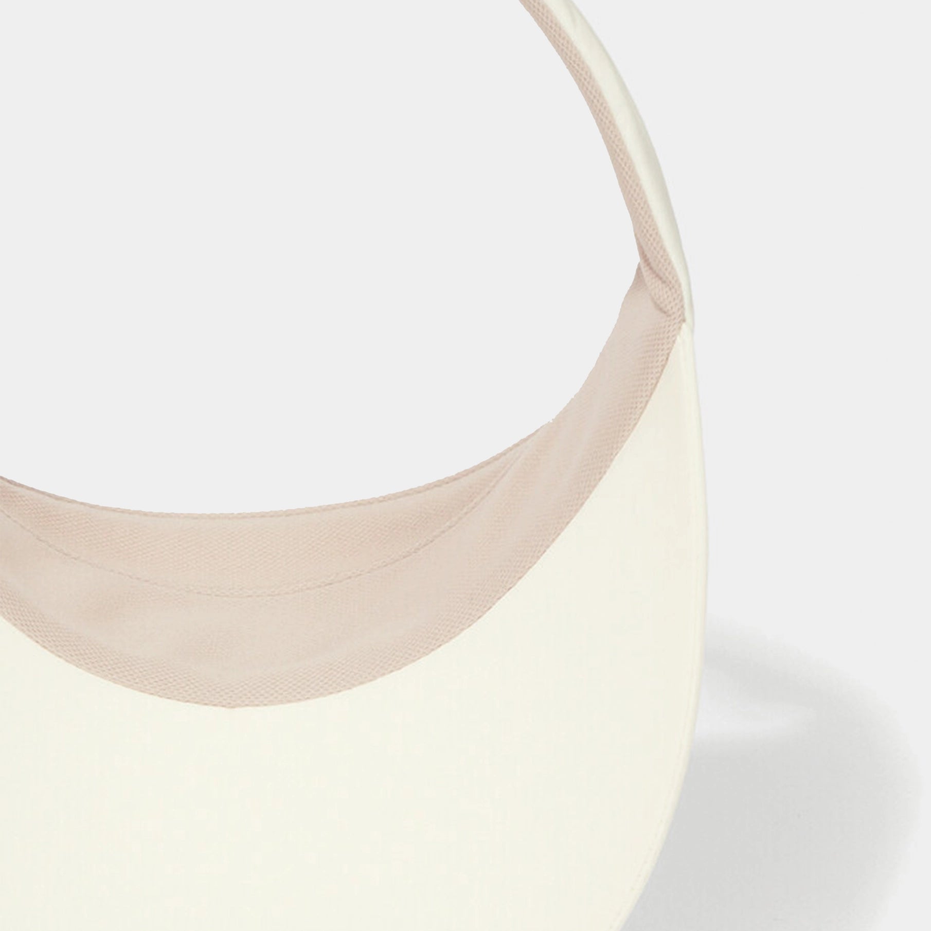 Close-up of a beige visor on a light gray background